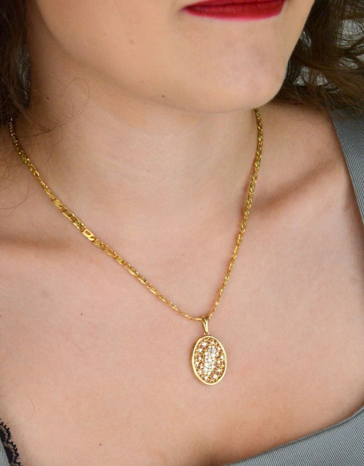 Złota zawieszka damska próby 585 o owalnym, ażurowym kształcie, zdobiona cyrkoniami. Wymiary 2,3 x 1,7 cm, waga 2,62 g. Elegancka i kobieca.1.jpg