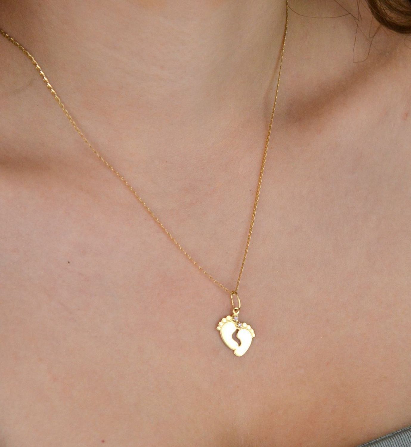 Złota zawieszka w kształcie stópek z różowymi cyrkoniami. Próba 585, długość 2,3 cm, waga 1,06 g. Urocza pamiątka narodzin dziecka lub wyjątkowy prezent dla mamy.1.jpg