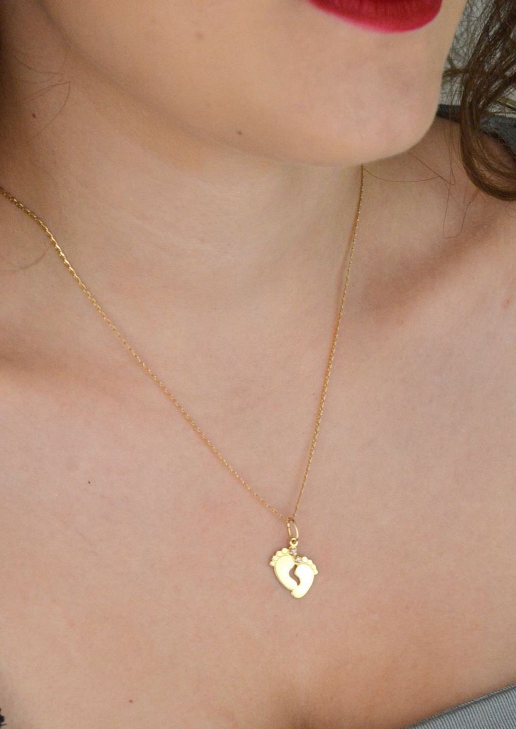 Złota zawieszka w kształcie stópek z różowymi cyrkoniami. Próba 585, długość 2,3 cm, waga 1,06 g. Urocza pamiątka narodzin dziecka lub wyjątkowy prezent dla mamy.1.jpg