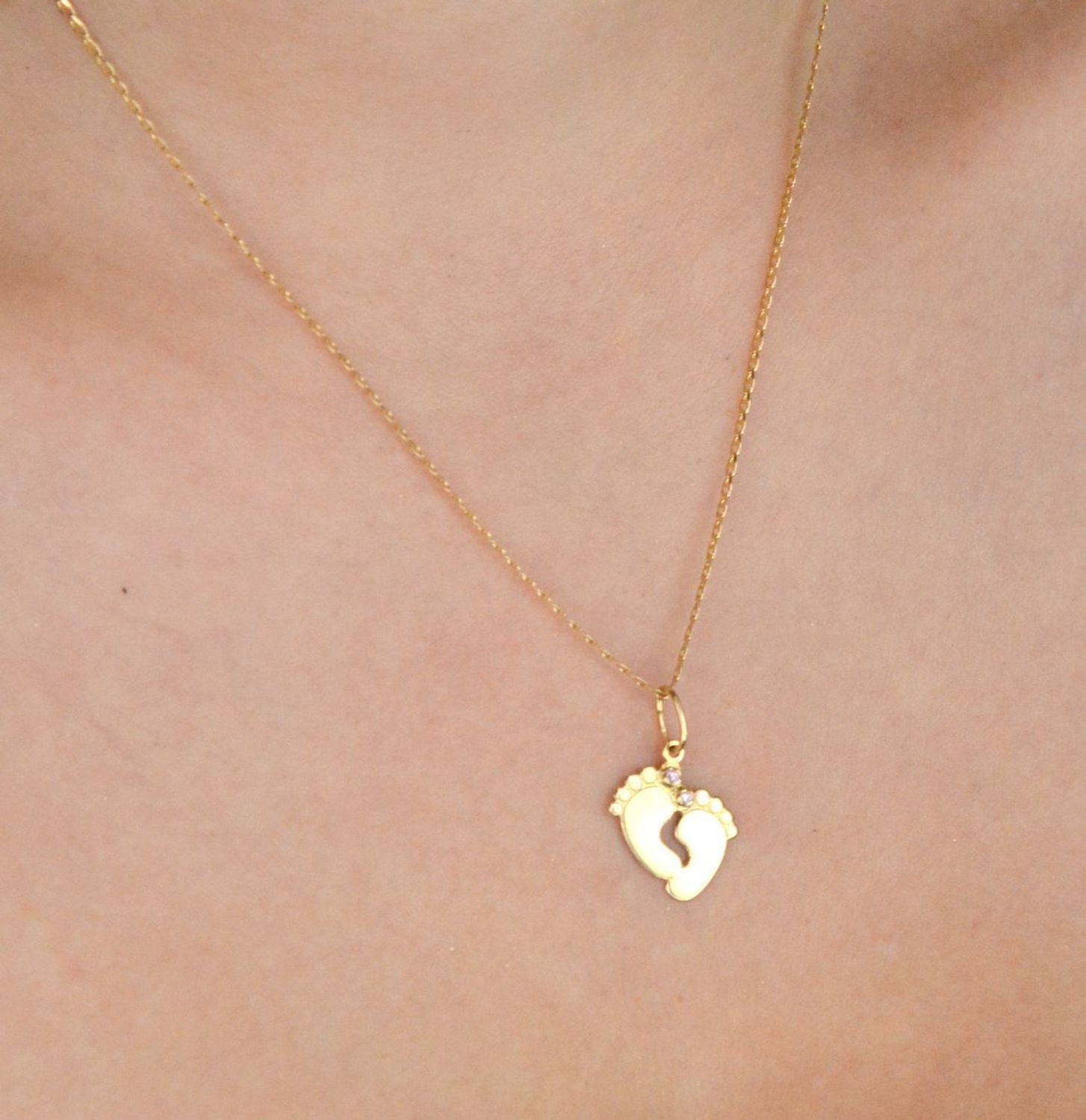 Złota zawieszka w kształcie stópek z różowymi cyrkoniami. Próba 585, długość 2,3 cm, waga 1,06 g. Urocza pamiątka narodzin dziecka lub wyjątkowy prezent dla mamy.1.jpg