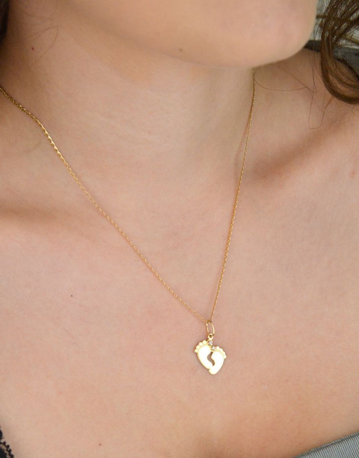 Złota zawieszka w kształcie stópek z różowymi cyrkoniami. Próba 585, długość 2,3 cm, waga 1,06 g. Urocza pamiątka narodzin dziecka lub wyjątkowy prezent dla mamy.1.jpg