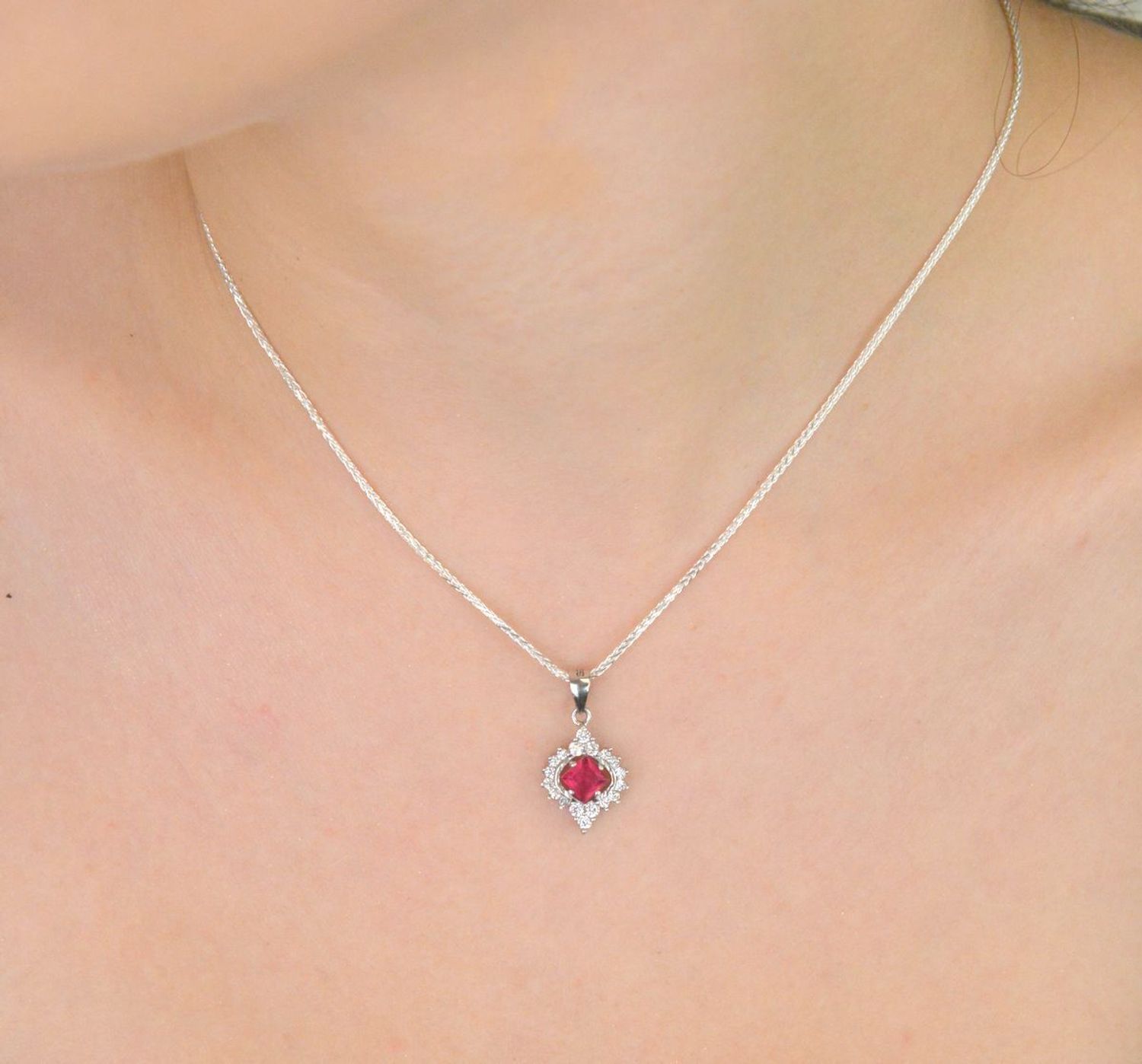 Elegancka zawieszka srebrna DIA-ZAW-13637-925 ozdobiona dużą czerwoną cyrkonią oraz mniejszymi białymi. Wykonana ze srebra próby 925, długość 2,2 cm, szerokość 1,2 cm, waga 1,60 g.1.jpg