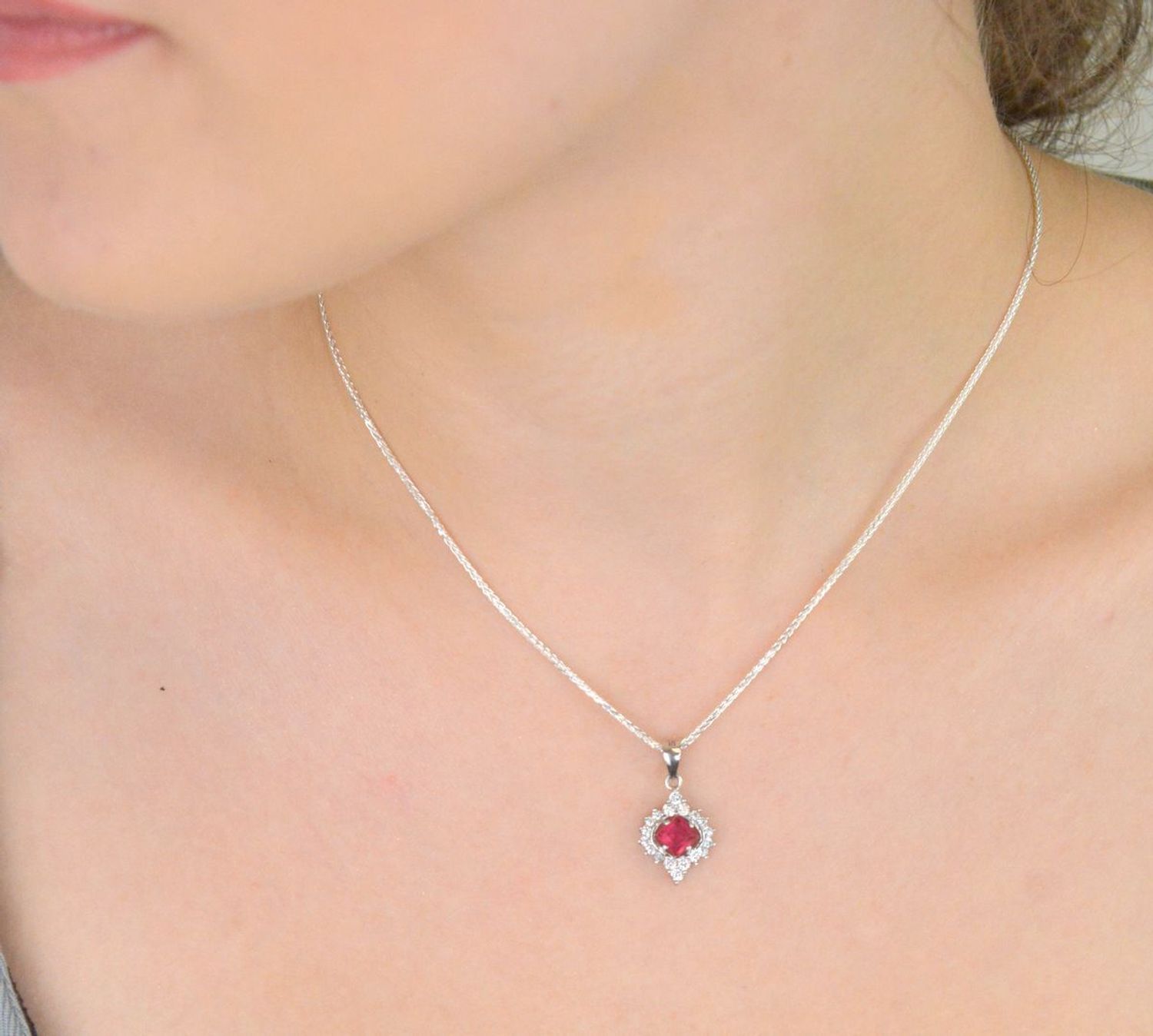 Elegancka zawieszka srebrna DIA-ZAW-13637-925 ozdobiona dużą czerwoną cyrkonią oraz mniejszymi białymi. Wykonana ze srebra próby 925, długość 2,2 cm, szerokość 1,2 cm, waga 1,60 g.1.jpg