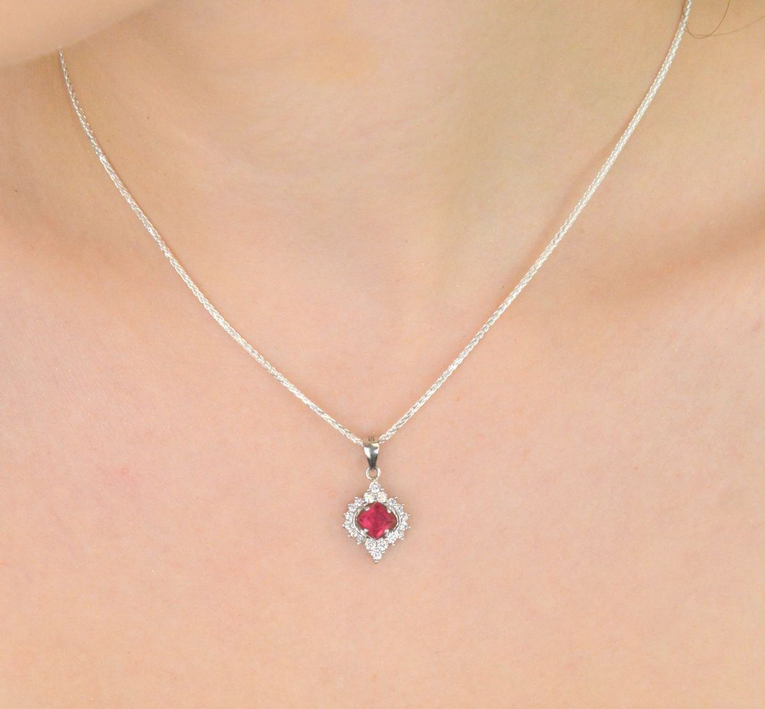 Elegancka zawieszka srebrna DIA-ZAW-13637-925 ozdobiona dużą czerwoną cyrkonią oraz mniejszymi białymi. Wykonana ze srebra próby 925, długość 2,2 cm, szerokość 1,2 cm, waga 1,60 g.1.jpg