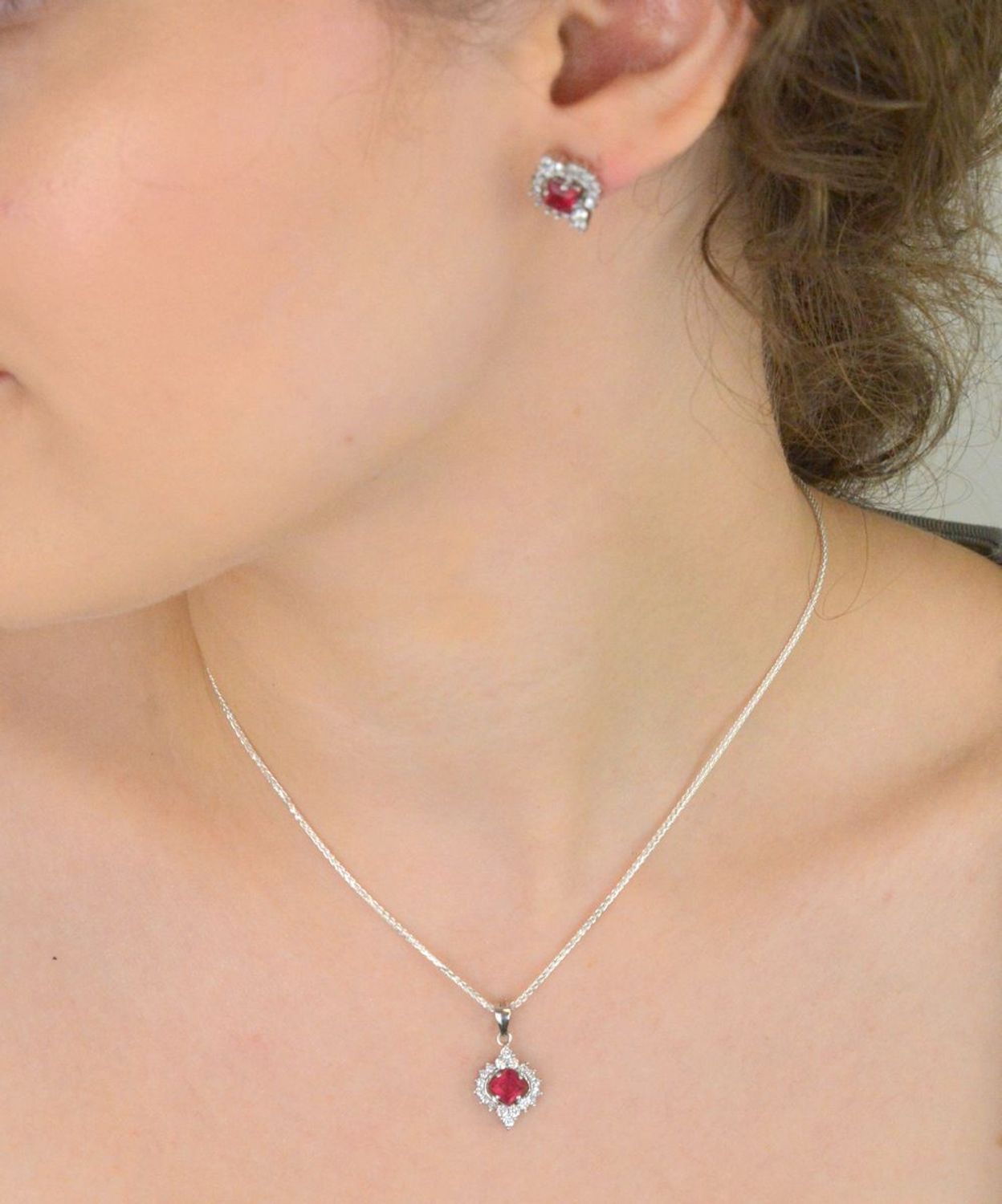 Elegancka zawieszka srebrna DIA-ZAW-13637-925 ozdobiona dużą czerwoną cyrkonią oraz mniejszymi białymi. Wykonana ze srebra próby 925, długość 2,2 cm, szerokość 1,2 cm, waga 1,60 g.1.jpg