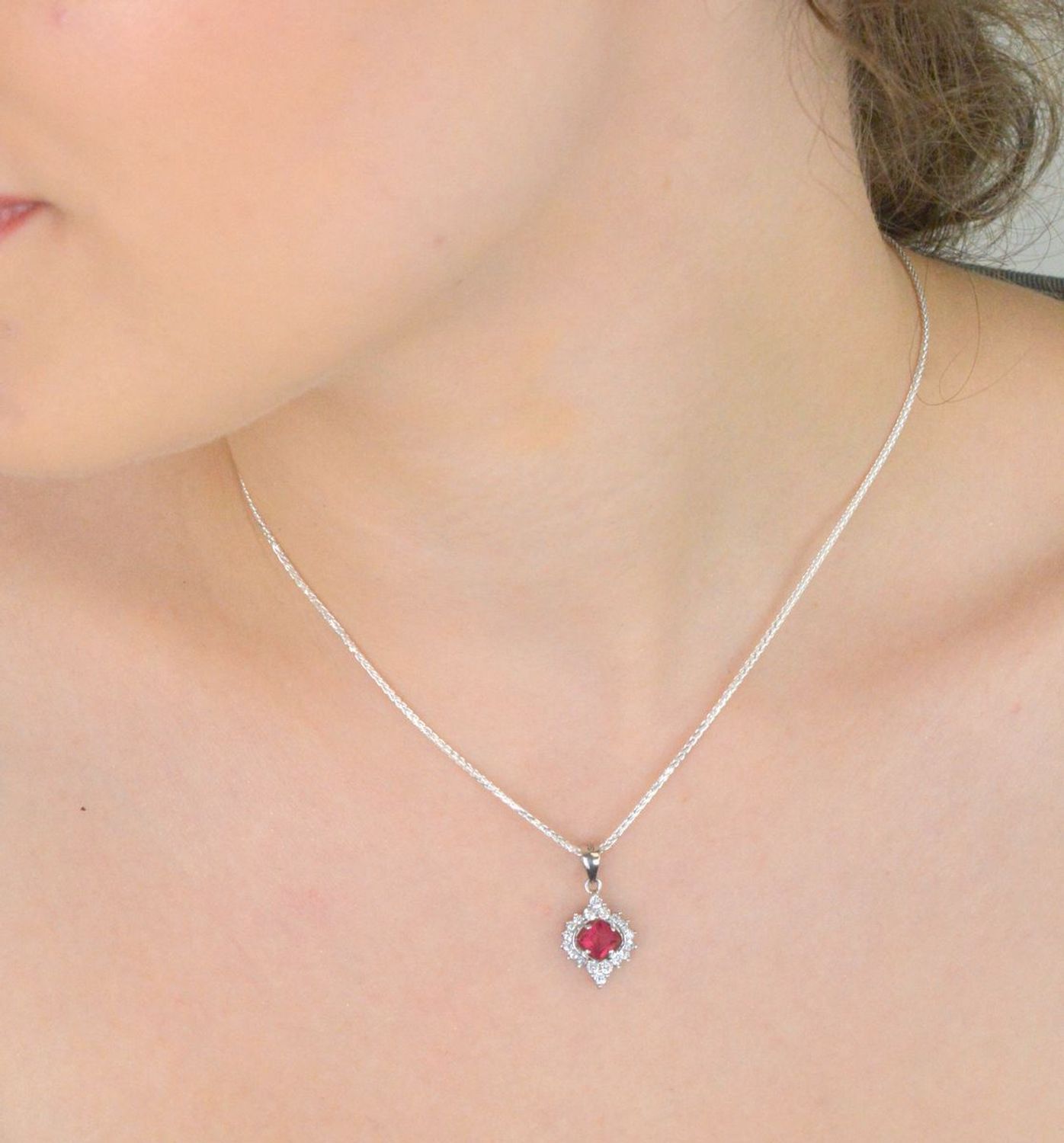 Elegancka zawieszka srebrna DIA-ZAW-13637-925 ozdobiona dużą czerwoną cyrkonią oraz mniejszymi białymi. Wykonana ze srebra próby 925, długość 2,2 cm, szerokość 1,2 cm, waga 1,60 g.1.jpg