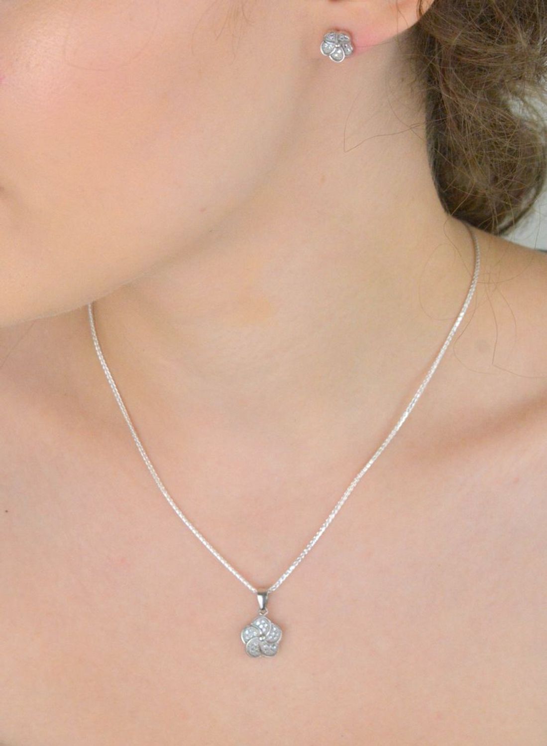 Elegancka zawieszka damska DIA-ZAW-13641-925 wykonana ze srebra próby 925 w kształcie kwiatka, ozdobiona lśniącymi cyrkoniami. Długość 2 cm, szerokość 1,2 cm, waga 1,40 g.1.jpg