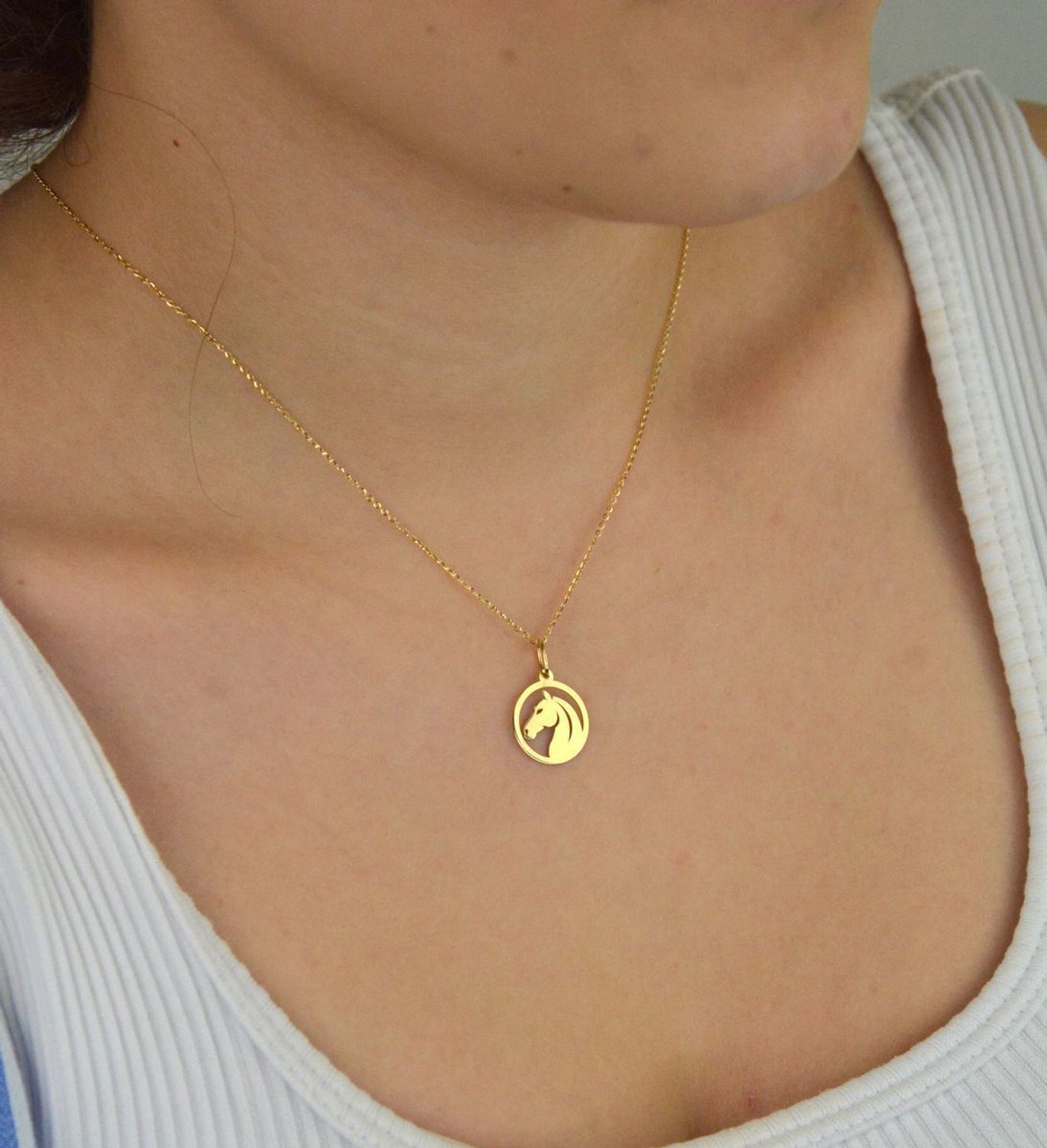 Stylowa zawieszka damska złota próby 585, model DIA-ZAW-13684-585. Okrągła z wizerunkiem głowy konia, wymiary 2,0 x 1,4 cm, waga 0,58 g. Idealna na prezent lub do codziennego noszenia.1.jpg