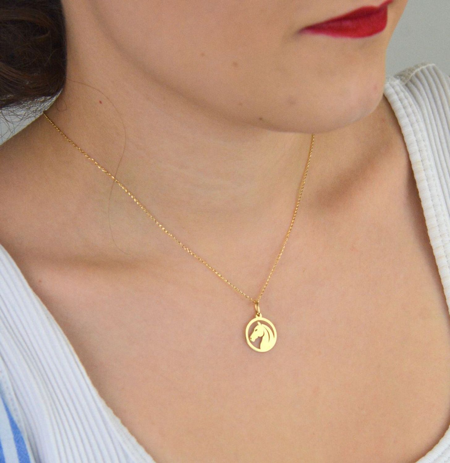 Stylowa zawieszka damska złota próby 585, model DIA-ZAW-13684-585. Okrągła z wizerunkiem głowy konia, wymiary 2,0 x 1,4 cm, waga 0,58 g. Idealna na prezent lub do codziennego noszenia.1.jpg