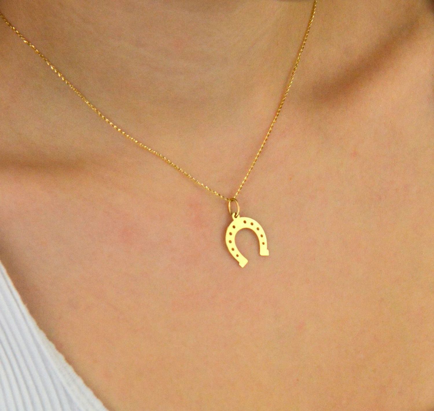 Stylowa zawieszka damska złota próby 585, model DIA-ZAW-13689-585 w kształcie podkowy. Długość z oczkiem 2,1 cm, szerokość 1,5 cm, waga 0,53 g. Idealna na prezent lub do codziennego noszenia.1.jpg