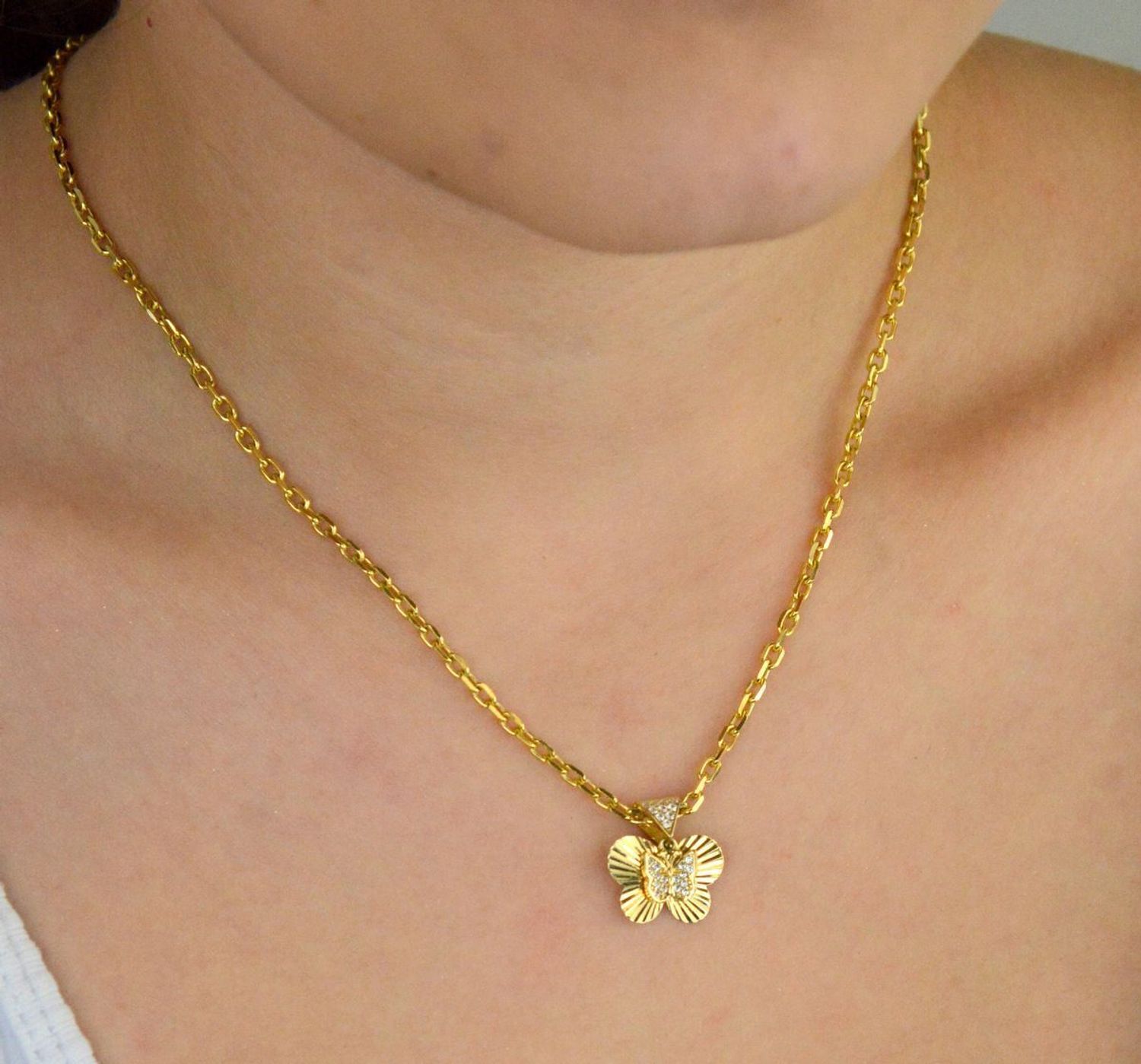 Zawieszka złota damska DIA-ZAW-13711-585 – motylek z wiszącym serduszkiem w cyrkonie. Wymiary 1,5 cm x 1,5 cm, waga 1,31 g. Delikatna i elegancka biżuteria idealna na prezent.1.jpg