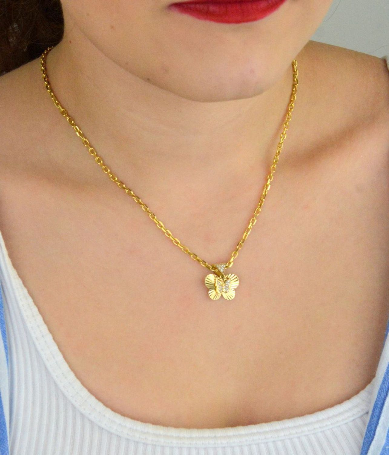 Zawieszka złota damska DIA-ZAW-13711-585 – motylek z wiszącym serduszkiem w cyrkonie. Wymiary 1,5 cm x 1,5 cm, waga 1,31 g. Delikatna i elegancka biżuteria idealna na prezent.1.jpg