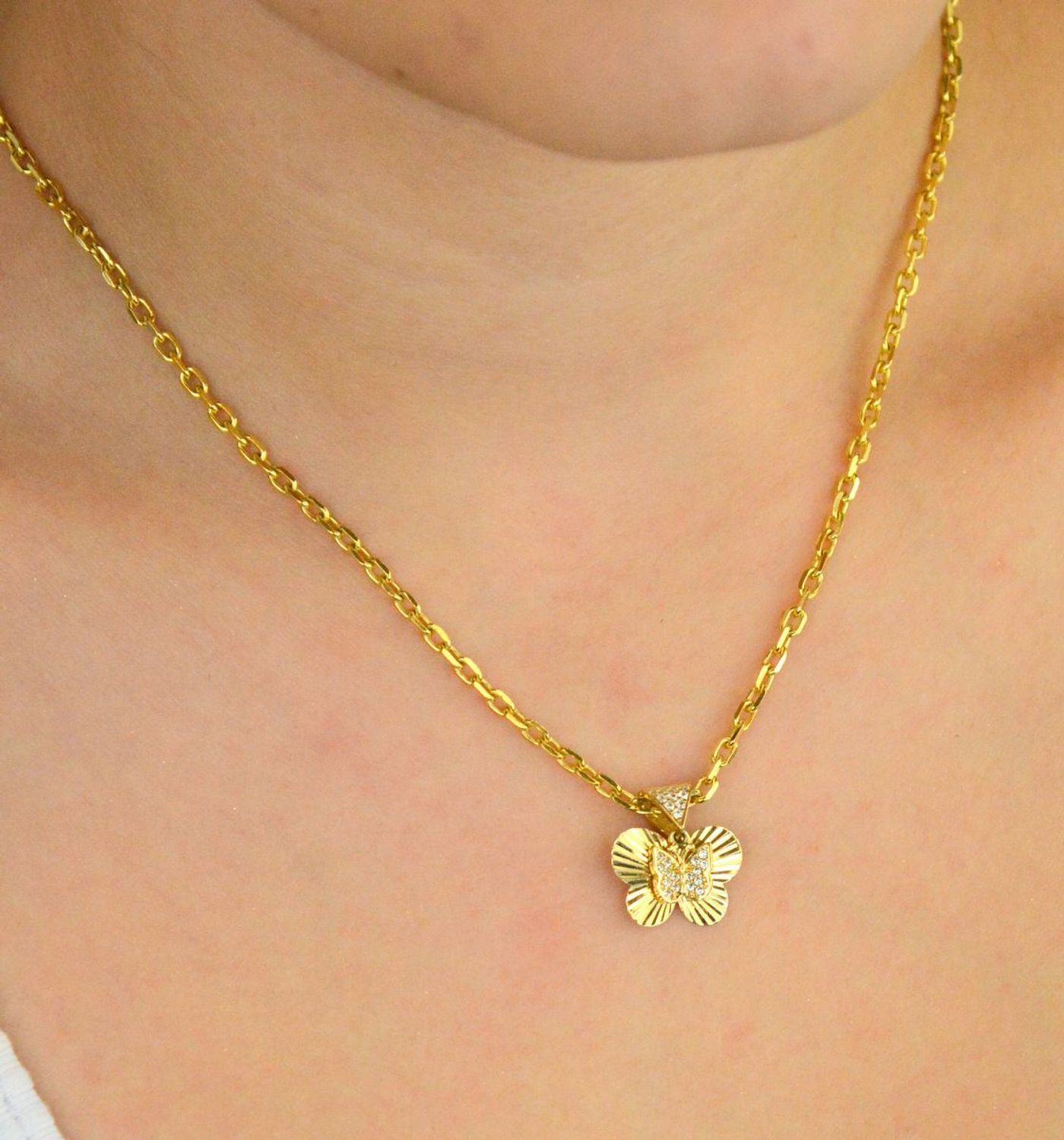 Zawieszka złota damska DIA-ZAW-13711-585 – motylek z wiszącym serduszkiem w cyrkonie. Wymiary 1,5 cm x 1,5 cm, waga 1,31 g. Delikatna i elegancka biżuteria idealna na prezent.1.jpg