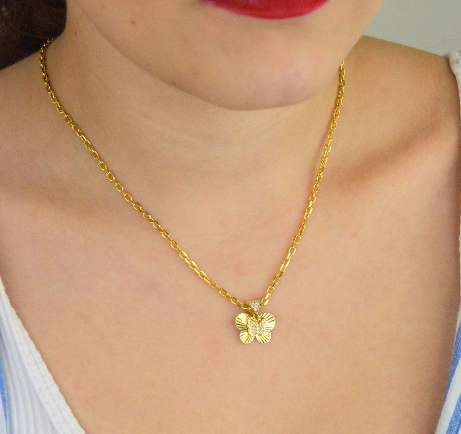 Zawieszka złota damska DIA-ZAW-13711-585 – motylek z wiszącym serduszkiem w cyrkonie. Wymiary 1,5 cm x 1,5 cm, waga 1,31 g. Delikatna i elegancka biżuteria idealna na prezent.1.jpg