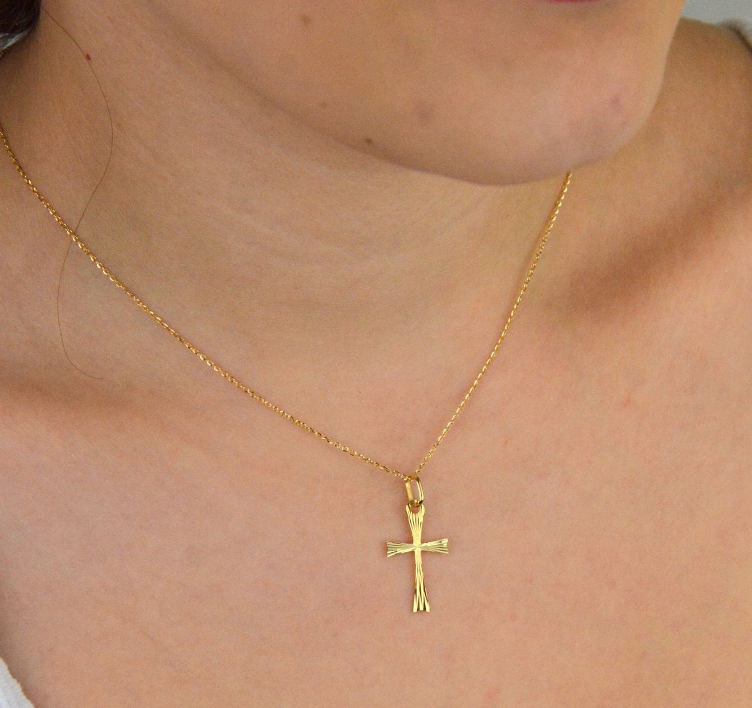 Zawieszka złota DIA-ZAW-13759-585 – krzyż grawerowany. Wymiary 2,5 cm x 1,3 cm, waga 0,44 g. Subtelna i elegancka biżuteria religijna, idealna na prezent.1.jpg