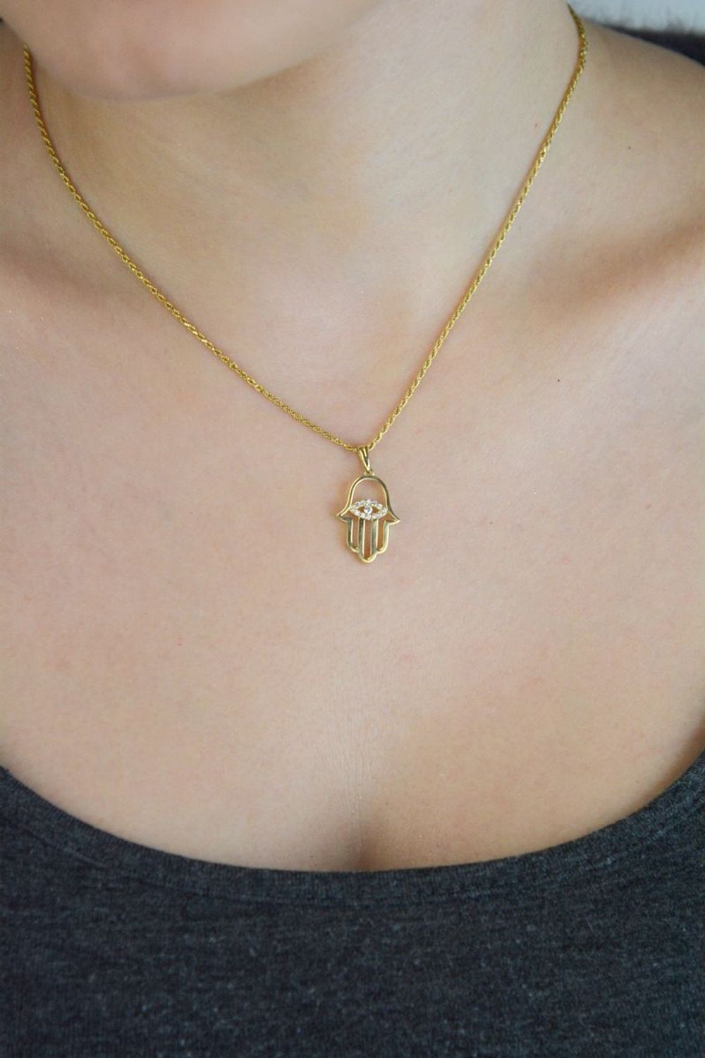 Elegancka zawieszka złota Ręka Fatimy z okiem próby 333, zdobiona białymi cyrkoniami. Wymiary 2,5×1,4 cm, waga 1,04 g. Idealny talizman i prezent.1.jpg