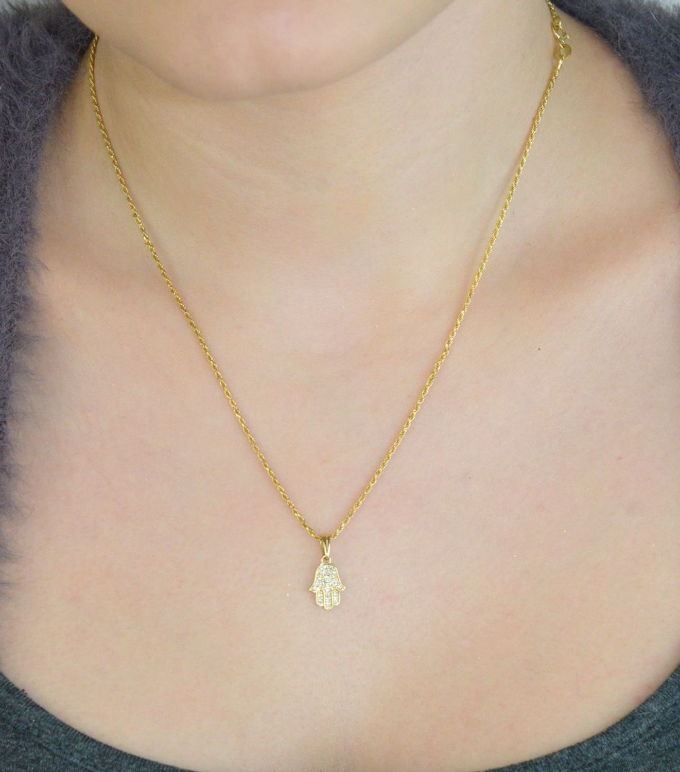 Subtelna zawieszka złota Ręka Fatimy próby 333, zdobiona cyrkoniami. Wymiary 1,7×0,8 cm, waga 0,56 g. Idealna jako prezent lub talizman ochronny.1.jpg