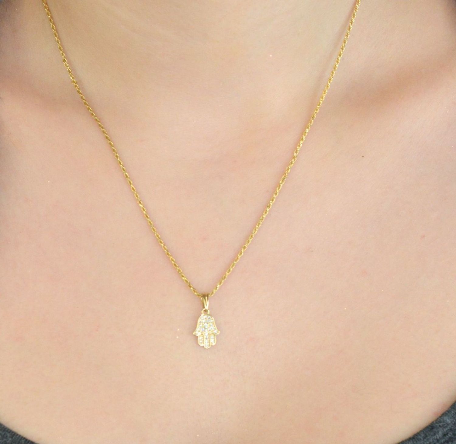 Subtelna zawieszka złota Ręka Fatimy próby 333, zdobiona cyrkoniami. Wymiary 1,7×0,8 cm, waga 0,56 g. Idealna jako prezent lub talizman ochronny.1.jpg