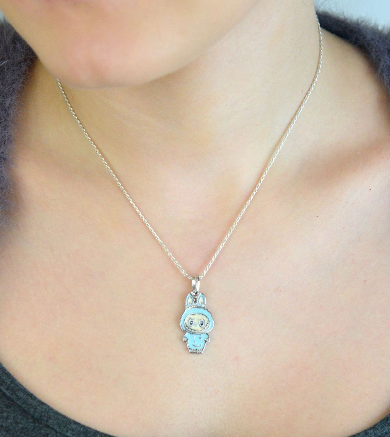 Zawieszka srebrna próby 925 w kształcie laleczki Labubu, zdobiona niebieską emalią. Model DIA-ZAW-13902-925, długość z oczkiem 3,0 cm, szerokość 1,3 cm, waga 3,00 g. Bajkowy i kolorowy prezent 1.jpg