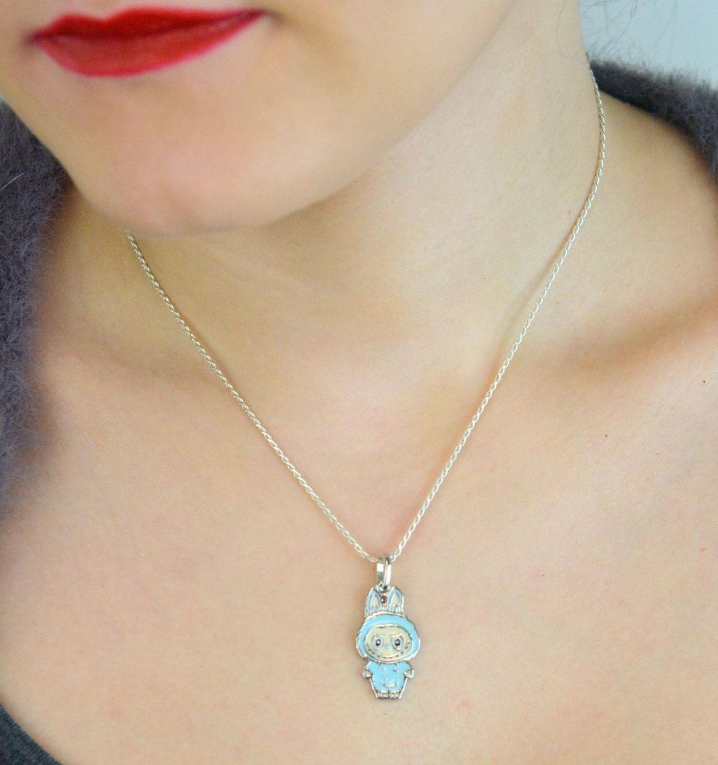 Zawieszka srebrna próby 925 w kształcie laleczki Labubu, zdobiona niebieską emalią. Model DIA-ZAW-13902-925, długość z oczkiem 3,0 cm, szerokość 1,3 cm, waga 3,00 g. Bajkowy i kolorowy prezent 1.jpg