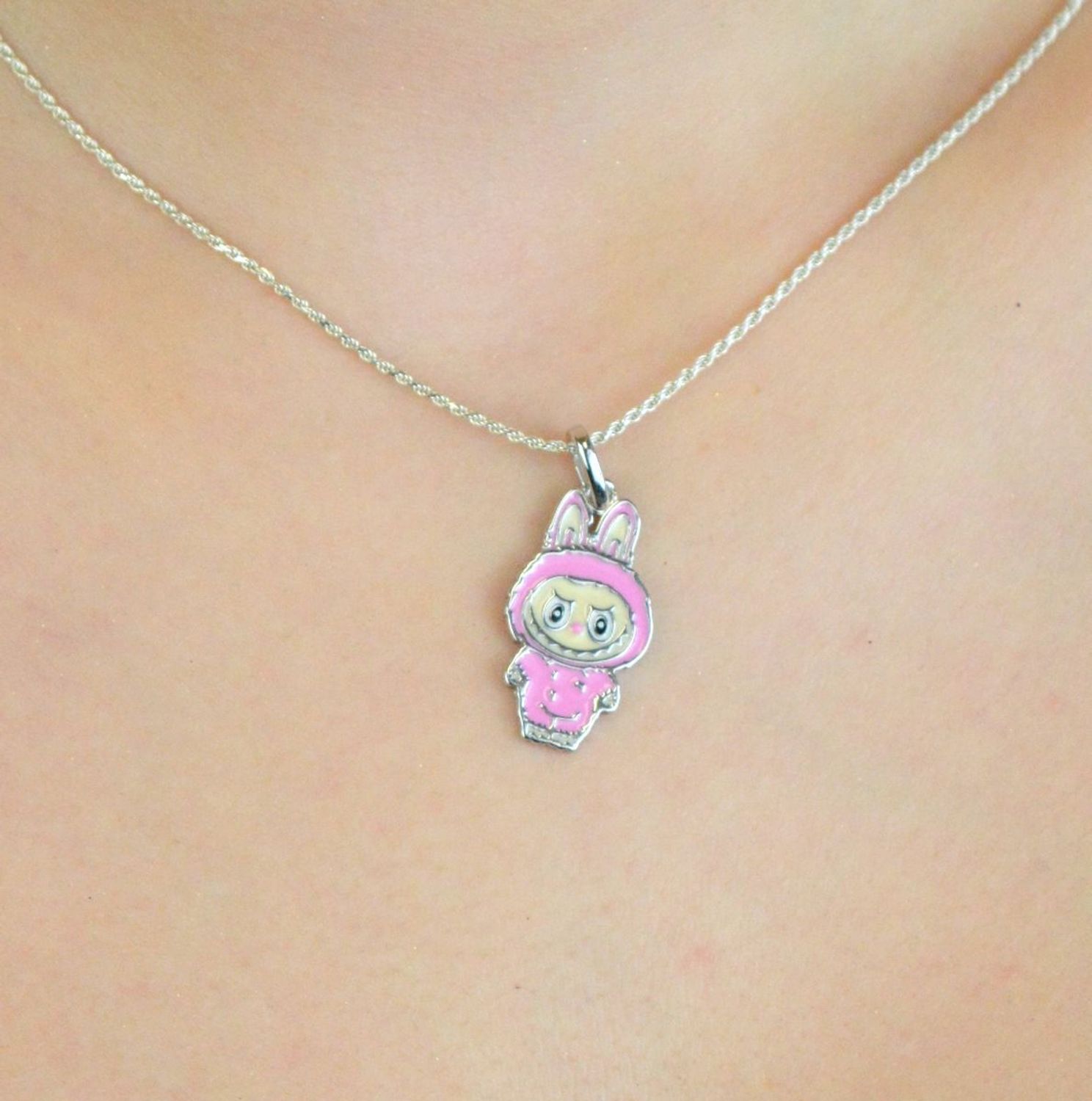 Zawieszka srebrna próby 925 w kształcie laleczki Labubu, zdobiona różową emalią. Model DIA-ZAW-13904-925, długość z oczkiem 3,0 cm, szerokość 1,3 cm, waga 3,00 g. Bajkowy i kolorowy prezent 1.jpg