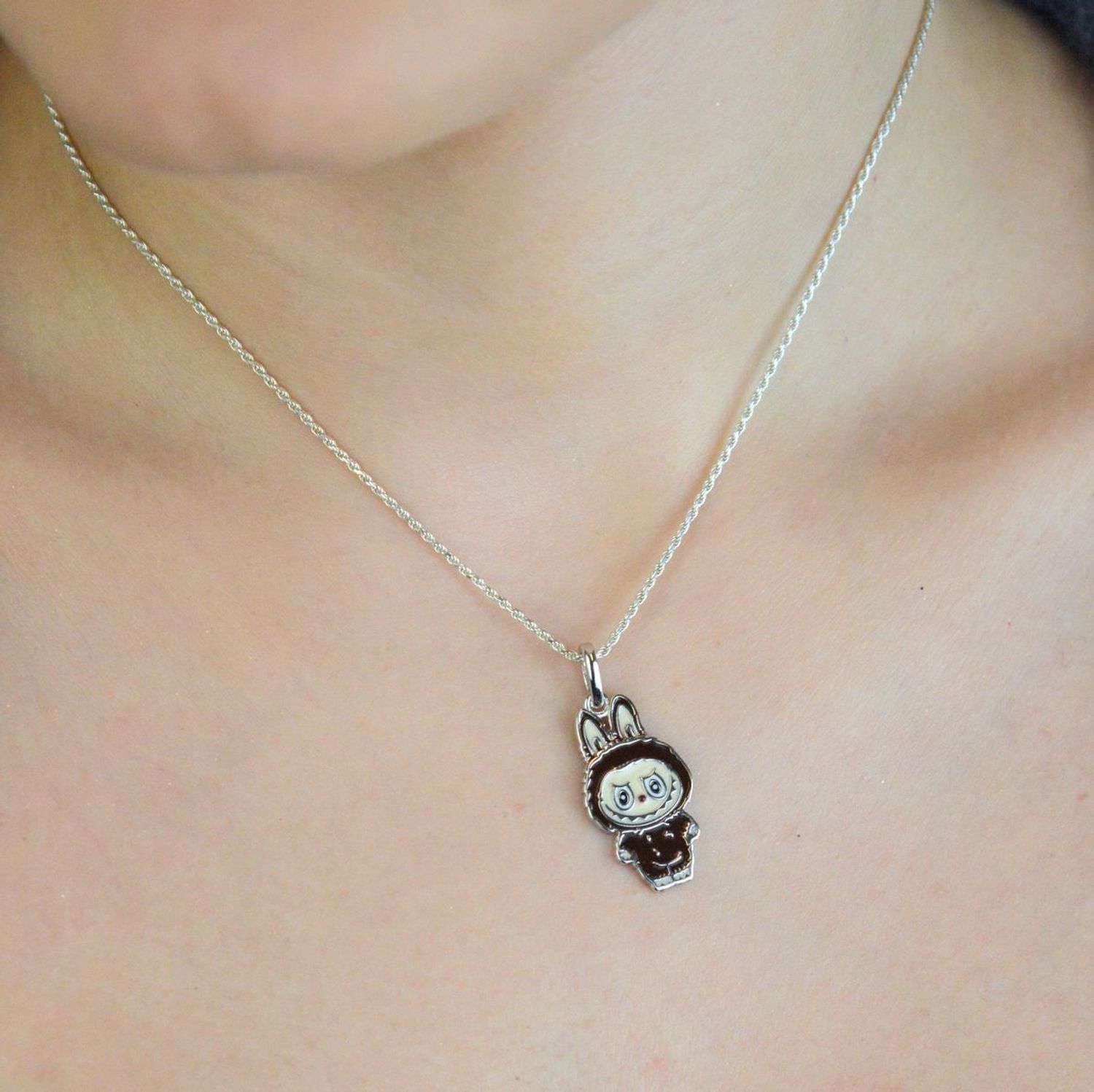 Zawieszka srebrna próby 925 w kształcie laleczki Labubu, zdobiona brązową emalią. Model DIA-ZAW-13906-925, długość 3,0 cm, szerokość 1,3 cm, waga 3,00 g. Bajkowy, kolorowy prezen1.jpg