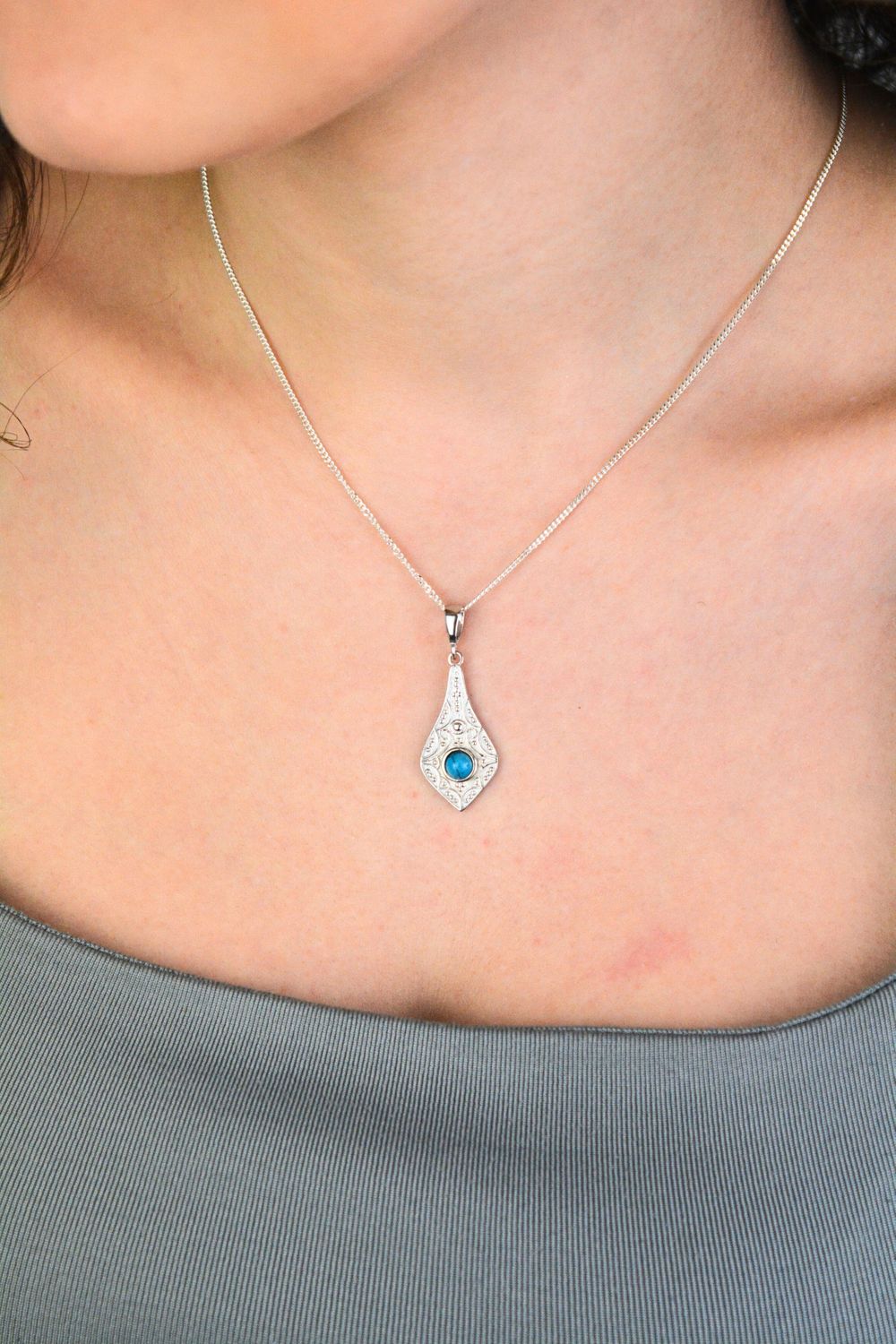 Elegancka zawieszka srebrna próby 925 w geometrycznym kształcie, zdobiona małym, okrągłym turkusem. Model DIA-ZAW-13996-925, długość z oczkiem 3,7 cm, szerokość 1,4 cm, waga 2,5 g. Idealny 1.jpg