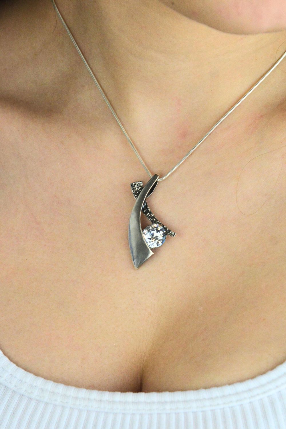 Damska zawieszka srebrna próby 925 DIA-ZAW-14078-925 o geometrycznym kształcie, zdobiona jedną cyrkonią. Długość 4,0 cm, szerokość 2,2 cm, waga 5,57 g. Nowoczesna i elegancka biżuteria.1.jpg