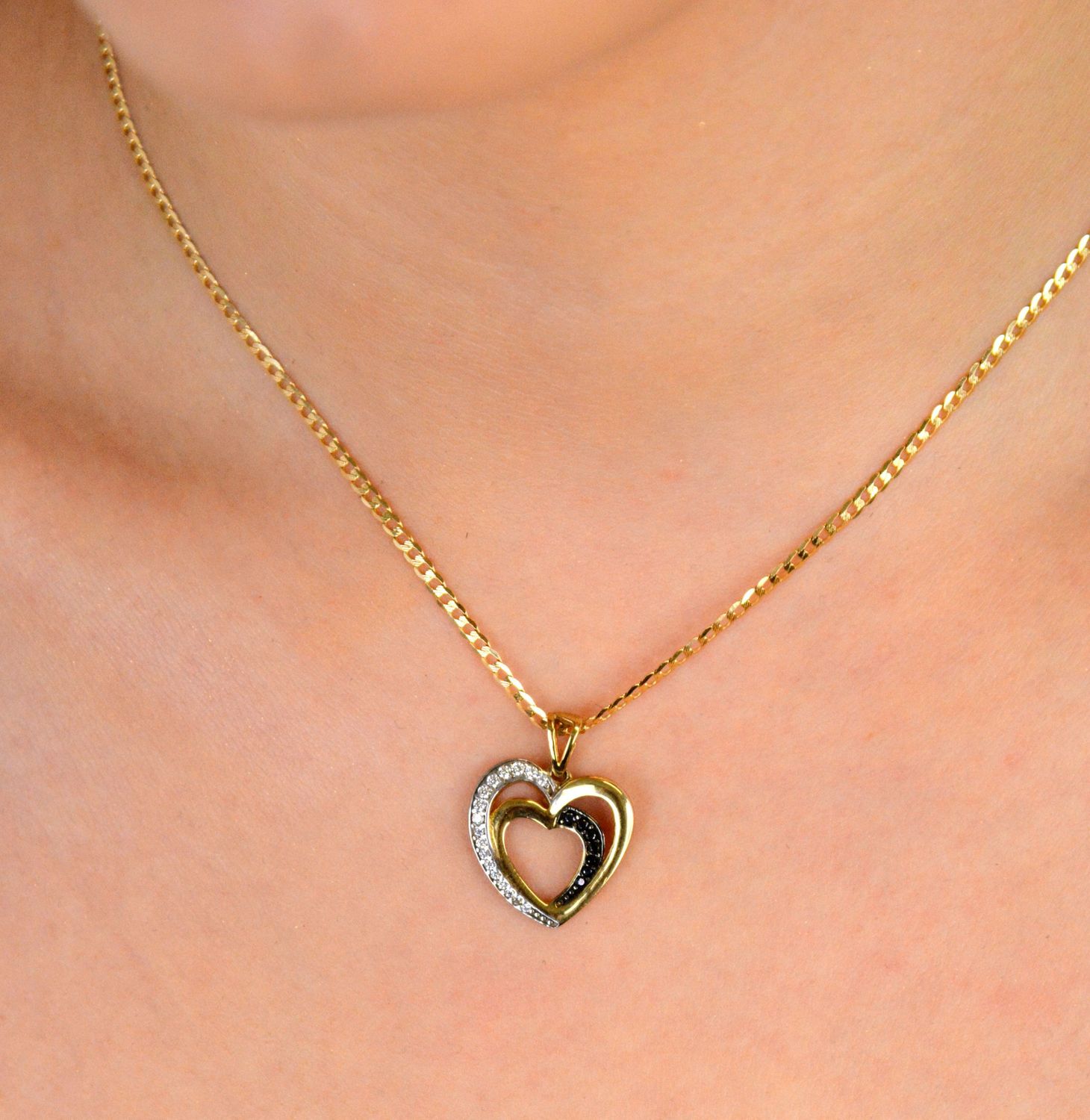 Złota zawieszka dwa serca ozdobione cyrkonią próba 333, DIA-ZAW-1537-333. Złota zawieszka dwa serca z białą i czarną cyrkonią – próba 333 💛 Złota zawieszka w kształcie dwóch splecionych serc 1.jpg