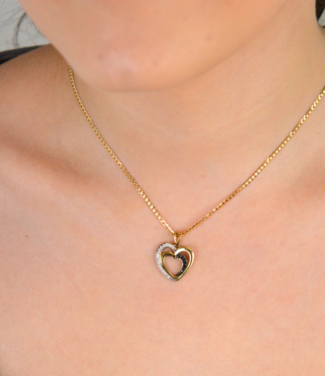 Złota zawieszka dwa serca ozdobione cyrkonią próba 333, DIA-ZAW-1537-333. Złota zawieszka dwa serca z białą i czarną cyrkonią – próba 333 💛 Złota zawieszka w kształcie dwóch splecionych serc 1.jpg