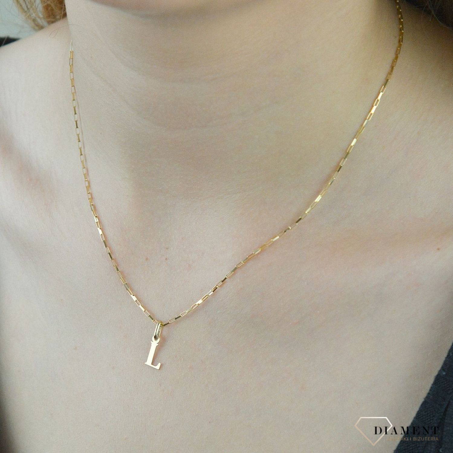 Złota zawieszka literka L 1 cm DIA-ZAW-2692L-585. Jedyna w swoim rodzaju złota zawieszka w kształcie literki L. Wisiorek został wykonany z najwyższej jakości złota próby 585. Złote literki to ostatni krzyk mody, uwielbiany prz.jpg