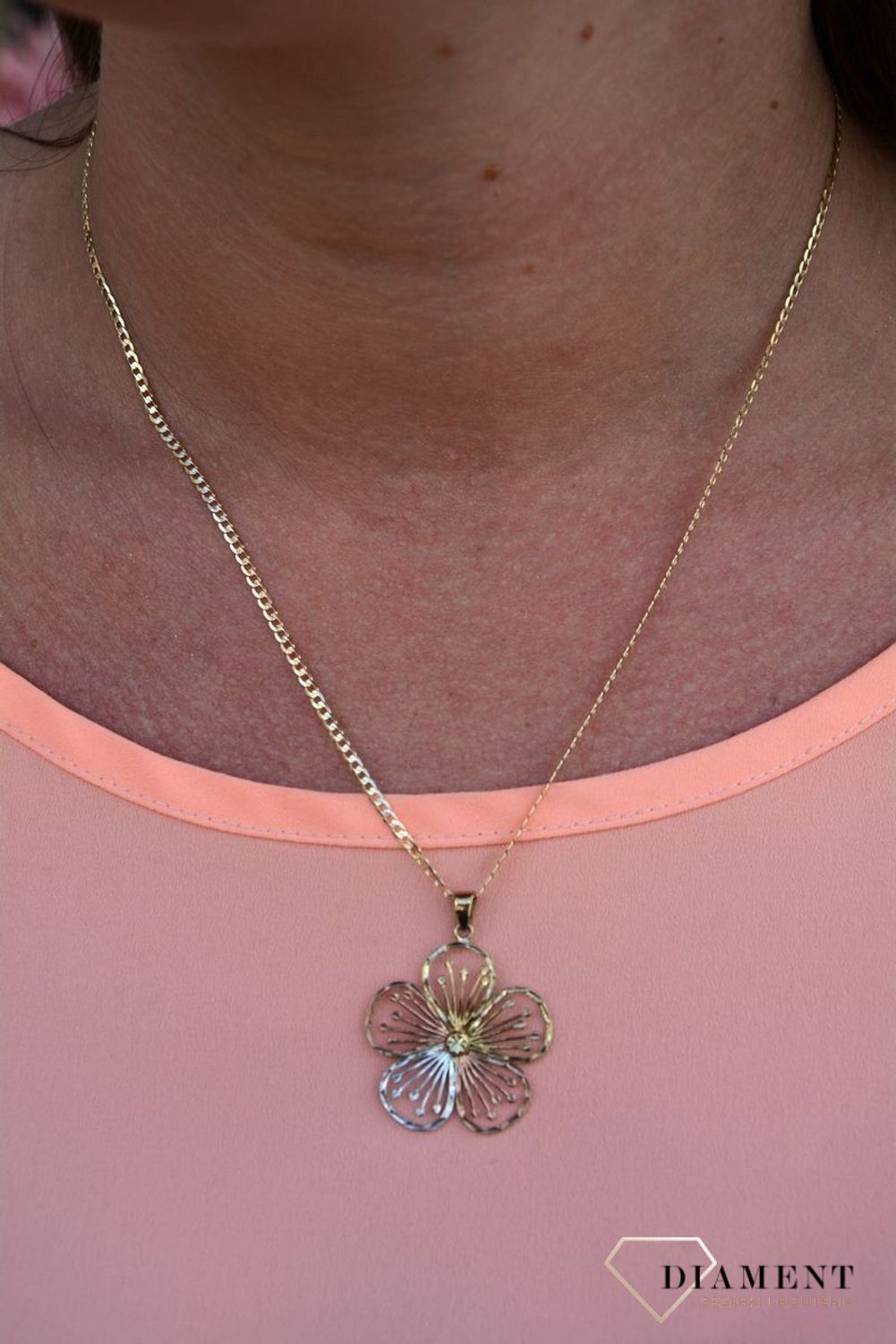 Zawieszka kwiatek próby 333 DIA-ZAW-3044-333. Złoty wisiorek w kształcie kwiatka wykonany z dodatkiem białego,różowego oraz żółtego złota. Wypełniony został grawerowanym motywem dzięki któremu zawieszka jest.jpg