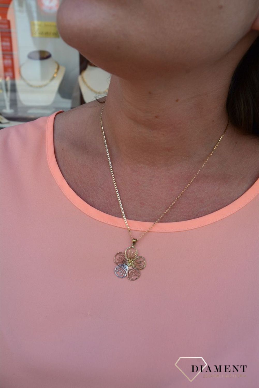 Zawieszka kwiatek próby 333 DIA-ZAW-3044-333. Złoty wisiorek w kształcie kwiatka wykonany z dodatkiem białego,różowego oraz żółtego złota. Wypełniony został grawerowanym motywem dzięki któremu zawieszka jest.jpg