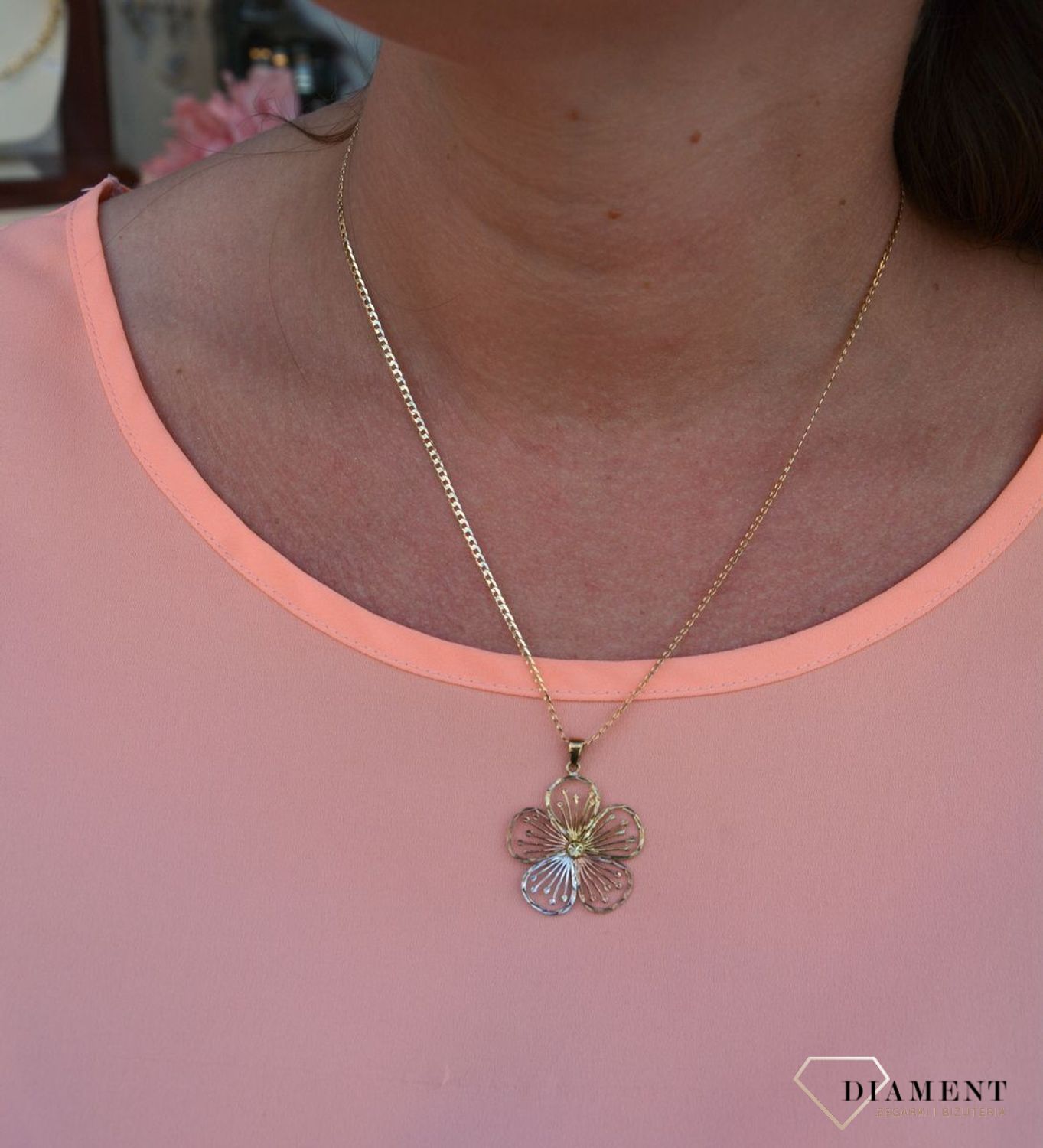 Zawieszka kwiatek próby 333 DIA-ZAW-3044-333. Złoty wisiorek w kształcie kwiatka wykonany z dodatkiem białego,różowego oraz żółtego złota. Wypełniony został grawerowanym motywem dzięki któremu zawieszka jest.jpg