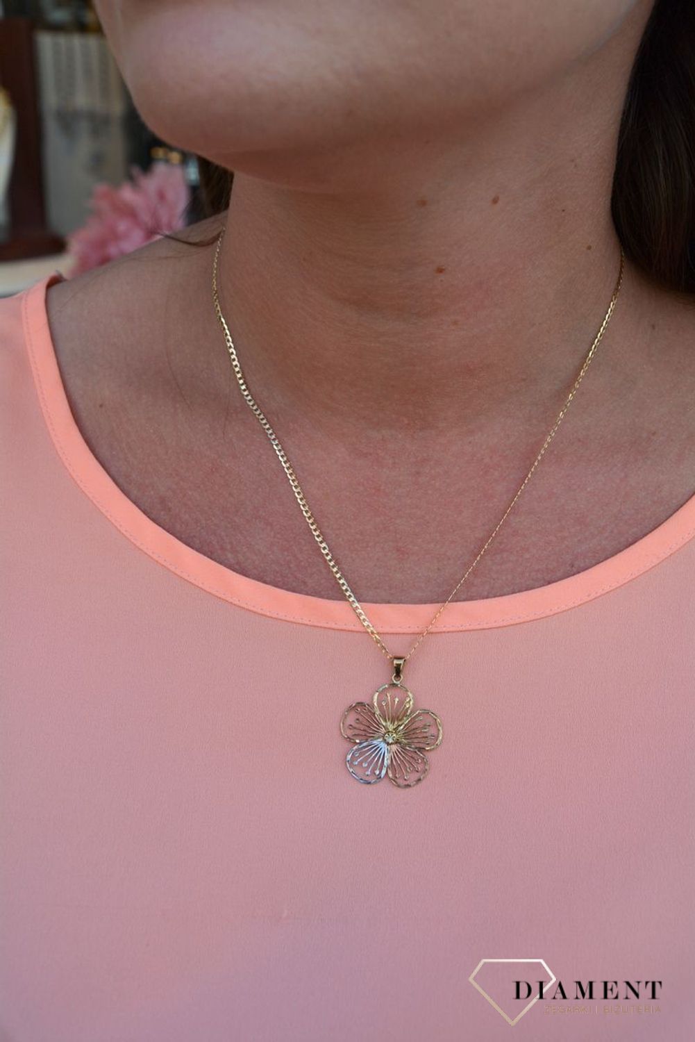 Zawieszka kwiatek próby 333 DIA-ZAW-3044-333. Złoty wisiorek w kształcie kwiatka wykonany z dodatkiem białego,różowego oraz żółtego złota. Wypełniony został grawerowanym motywem dzięki któremu zawieszka jest.jpg