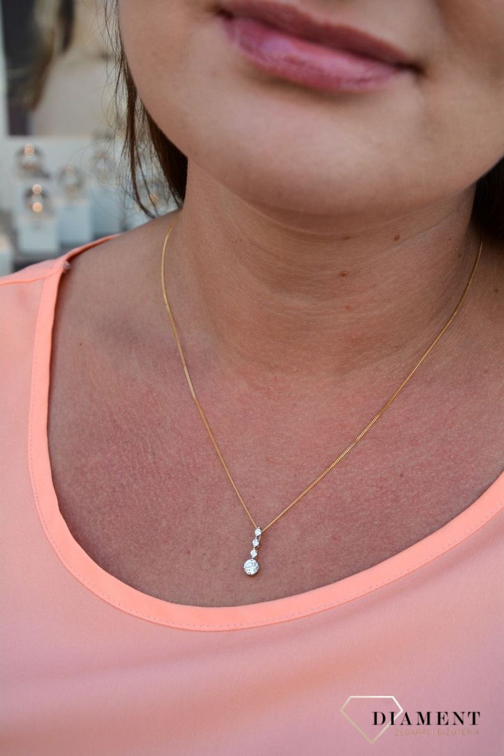 Zawieszka cyrkonie próby 333 DIA-ZAW-3047-333.  Złoty wisiorek o podłużnym kształcie z jedną większą cyrkonią oraz trzema mniejszymi. Wisiorek ten to idealny pomysł na prezent, którym wyjawimy swoje uczucia..jpg