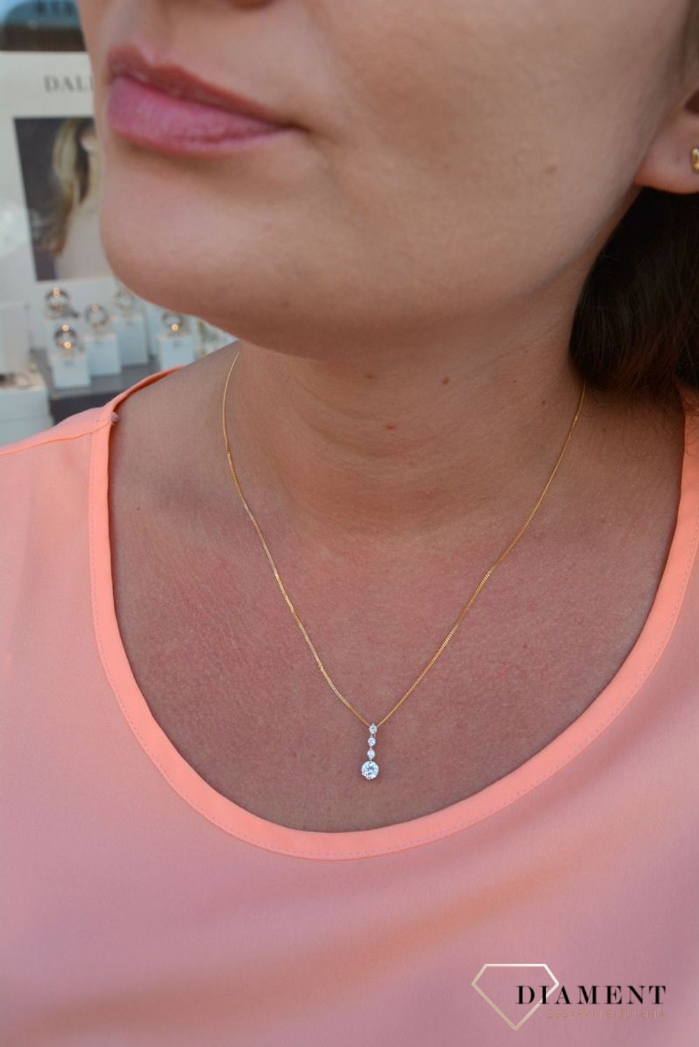 Zawieszka cyrkonie próby 333 DIA-ZAW-3047-333.  Złoty wisiorek o podłużnym kształcie z jedną większą cyrkonią oraz trzema mniejszymi. Wisiorek ten to idealny pomysł na prezent, którym wyjawimy swoje uczucia..jpg