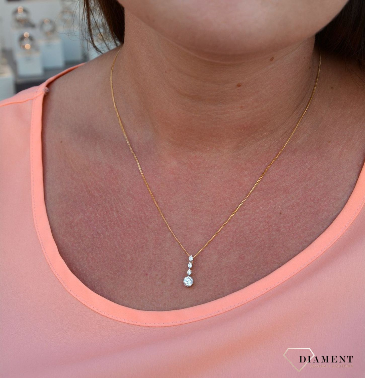 Zawieszka cyrkonie próby 333 DIA-ZAW-3047-333.  Złoty wisiorek o podłużnym kształcie z jedną większą cyrkonią oraz trzema mniejszymi. Wisiorek ten to idealny pomysł na prezent, którym wyjawimy swoje uczucia..jpg