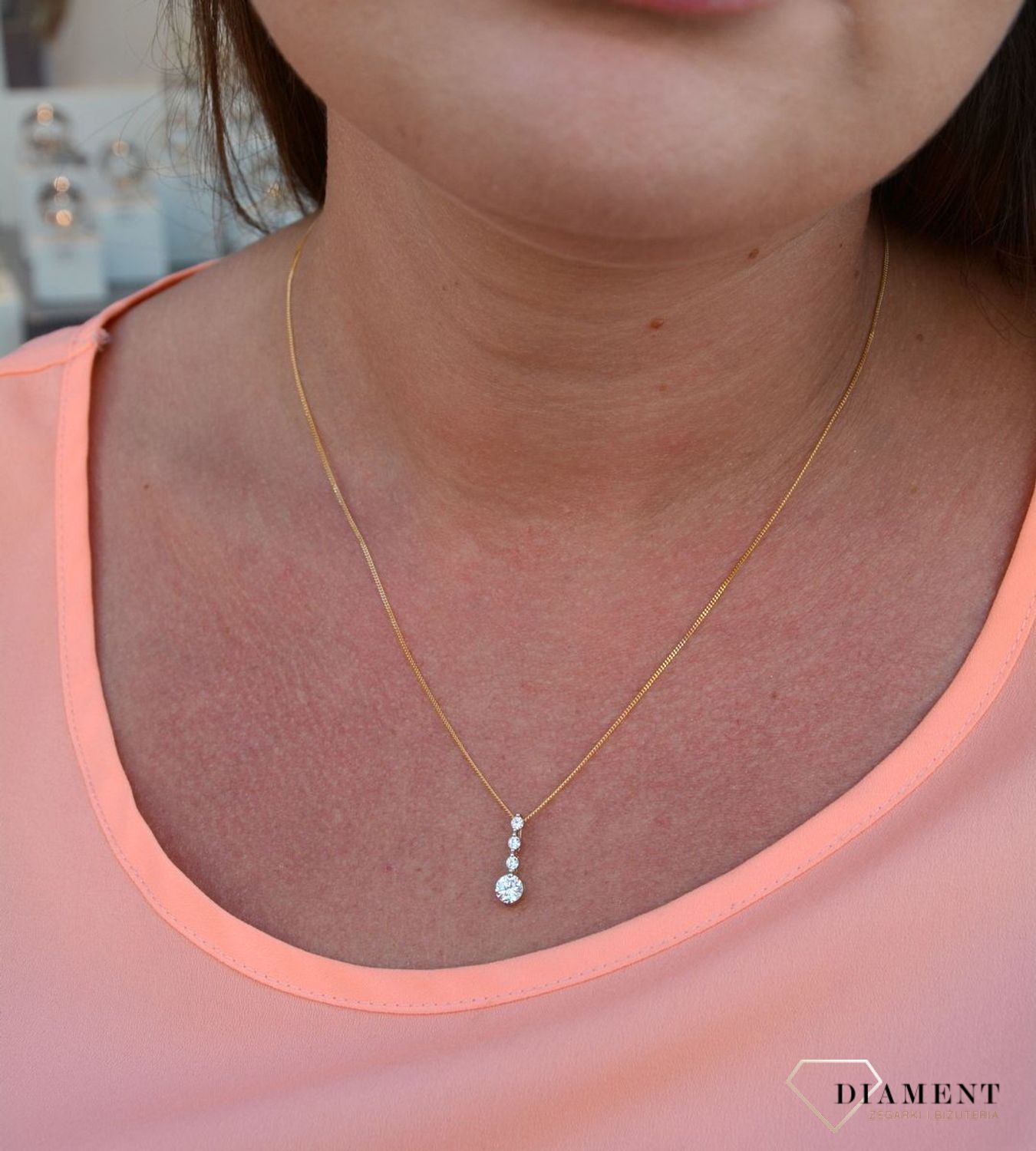 Zawieszka cyrkonie próby 333 DIA-ZAW-3047-333.  Złoty wisiorek o podłużnym kształcie z jedną większą cyrkonią oraz trzema mniejszymi. Wisiorek ten to idealny pomysł na prezent, którym wyjawimy swoje uczucia..jpg