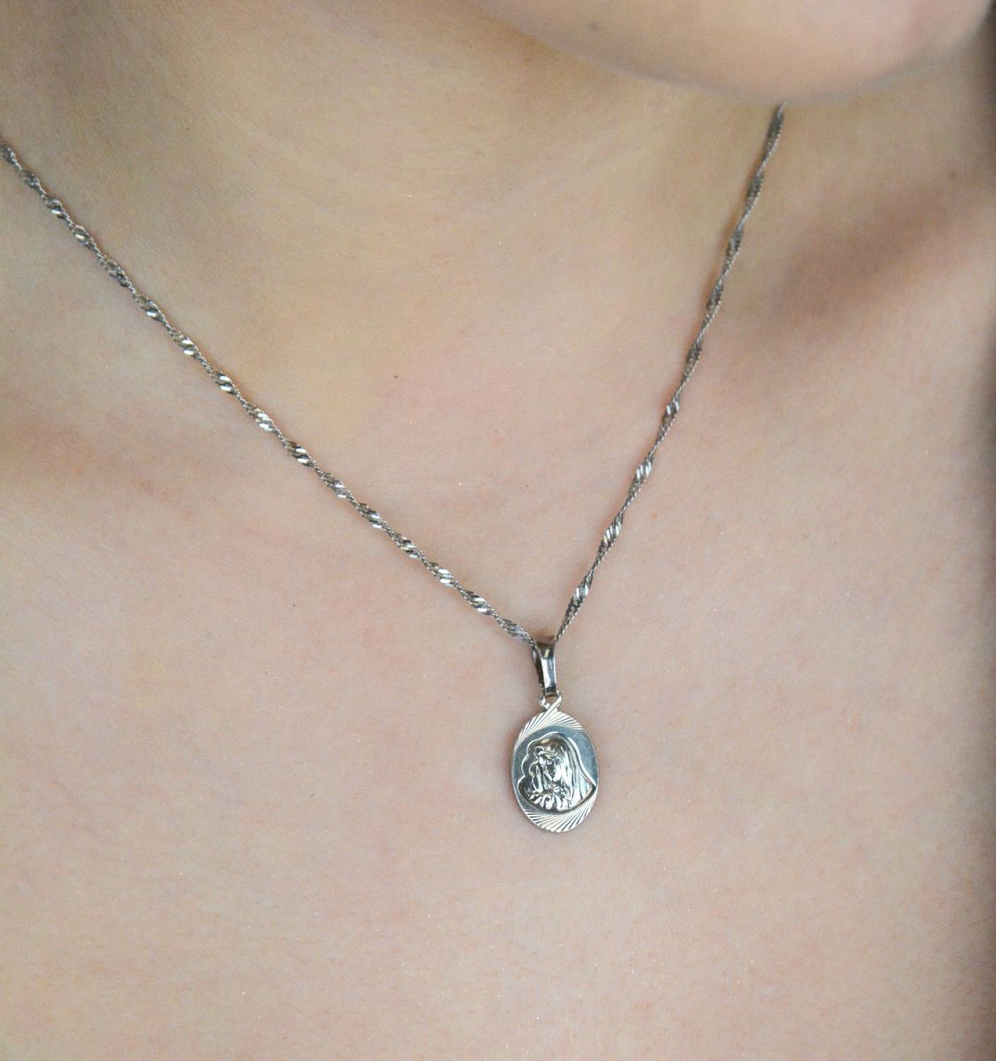 Srebrny medalik z wizerunkiem Matki Boskiej, model DIA-ZAW-3739-925, próba 925. Waga 1,80 g, wymiary 2,5 × 1,1 cm. Idealny religijny symbol wiary i ochrony.1.jpg