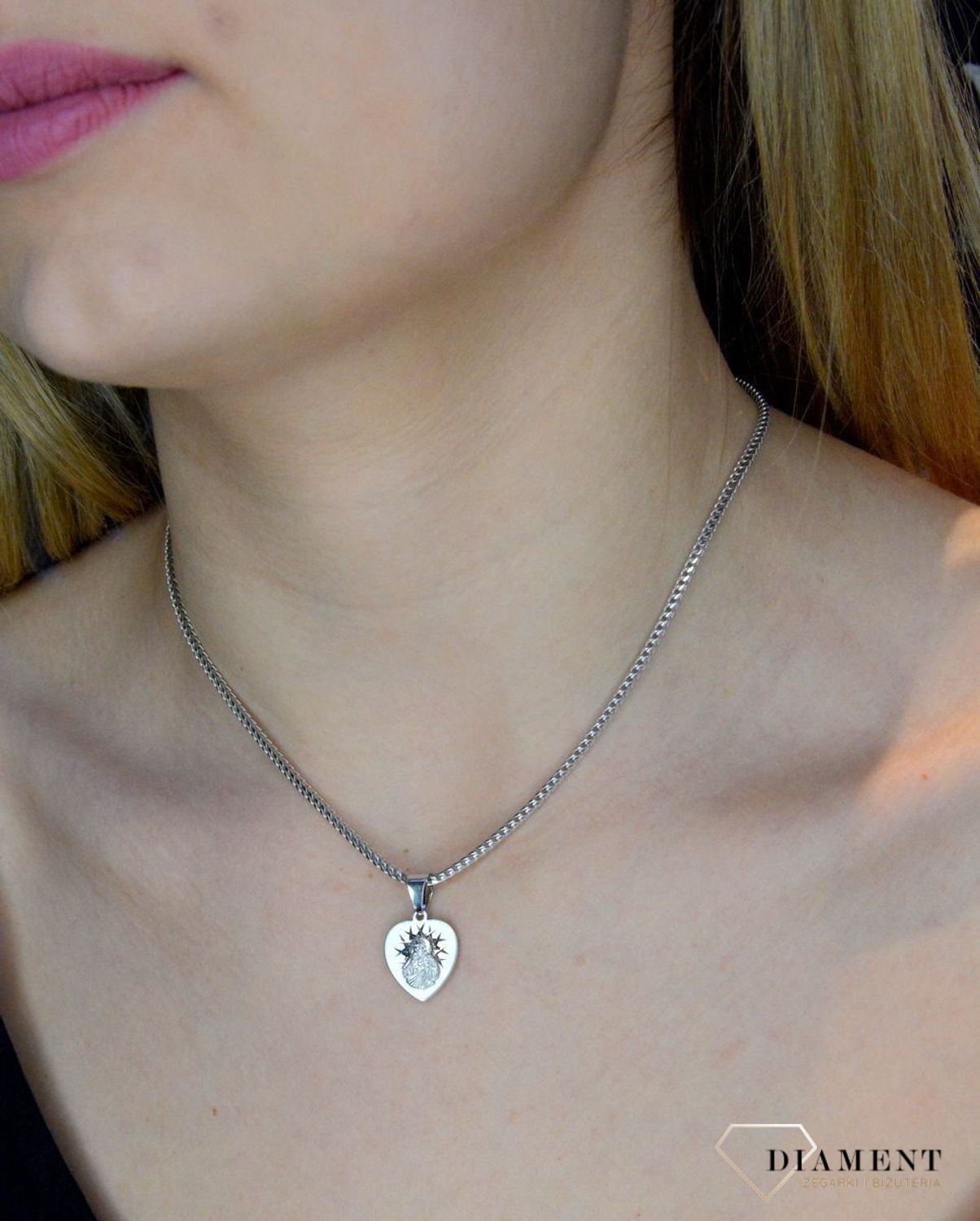 Srebrna zawieszka w kształcie serca z wizerunkiem Matki Boskiej DIA-ZAW-40245C-925. Idealnie będzie pasował do srebrny subtelnych łańcuszków. Sprawdzi się również jako idealny prezent na komunię bądź chrzciny dla dziecka.jpg