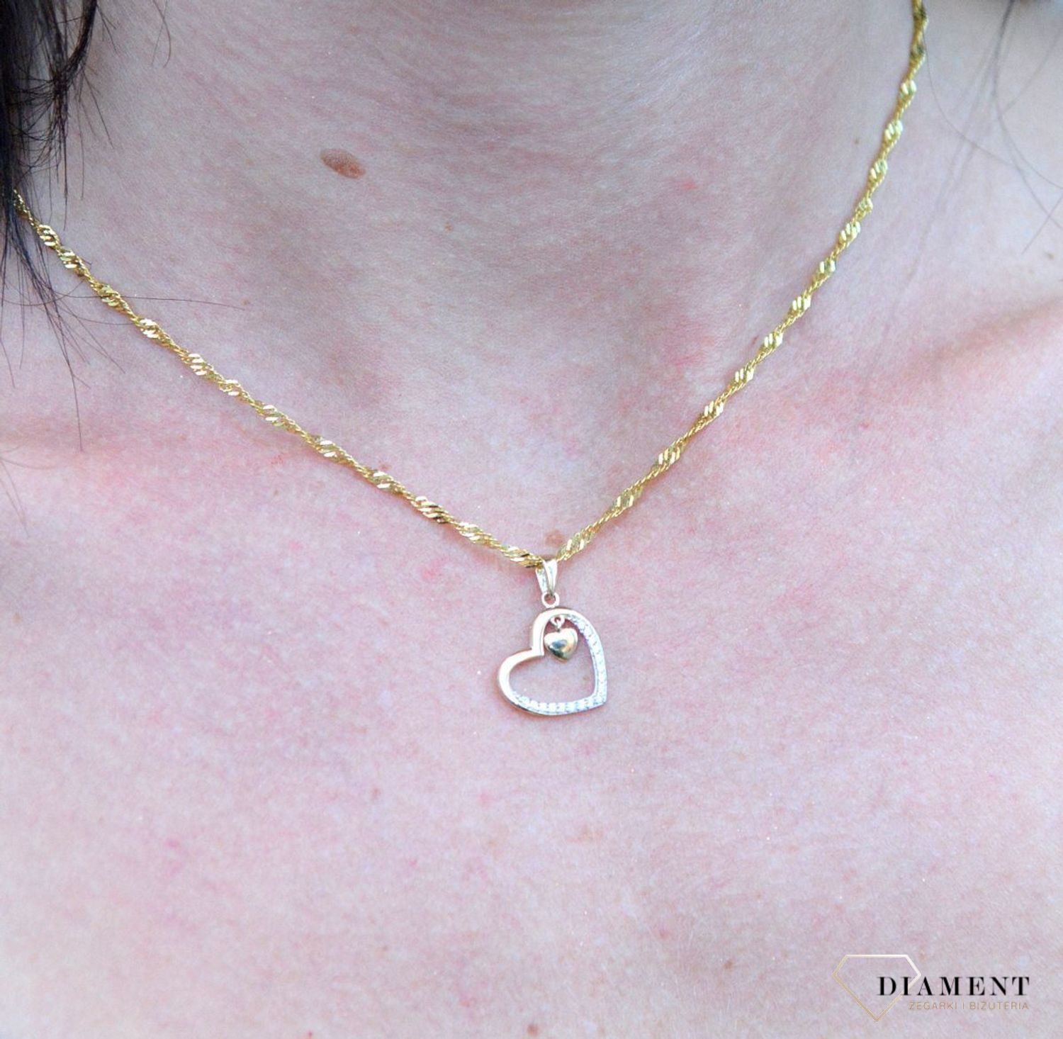 Złota zawieszka serce ozdobione cyrkonią z małym wiszącym serduszkiem DIA-ZAW-4390-585. Złota zawieszka w kształcie serca ozdobione częściowo błyszczącą cyrkonią.jpg