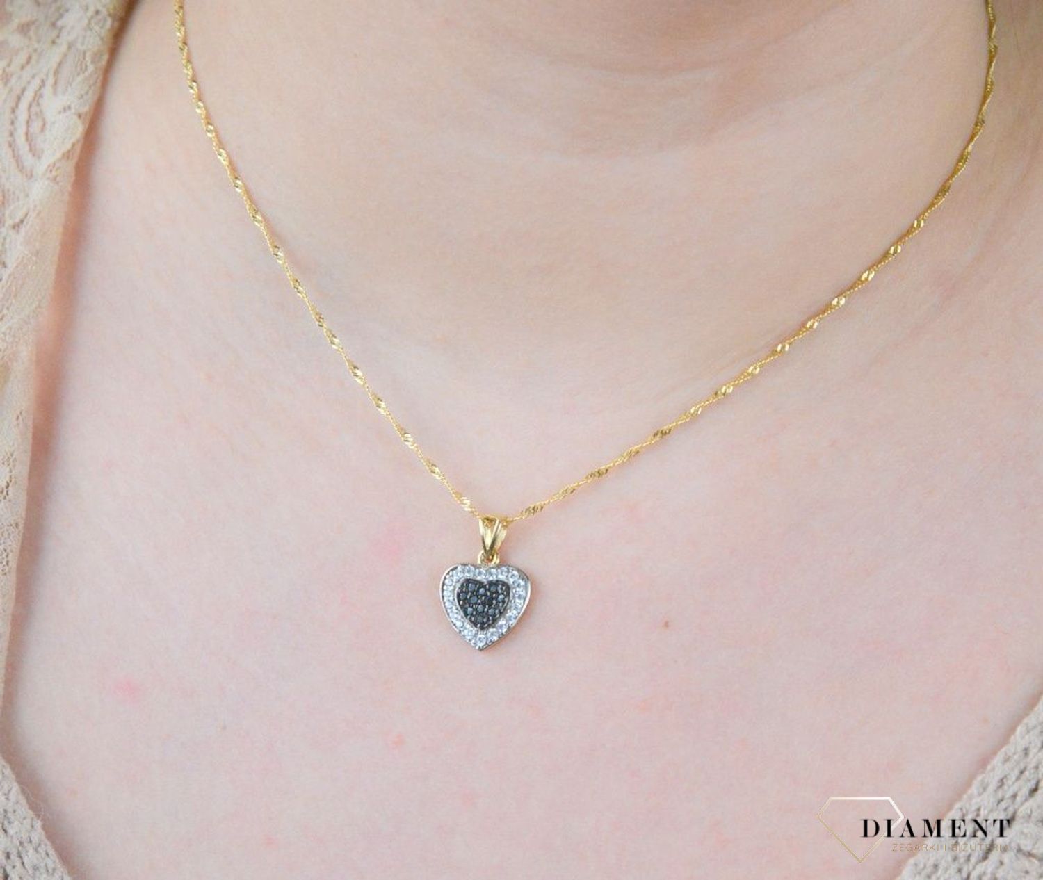Piękna zawieszka w kształcie serca ozdobiona cyrkonią w kolorze białym i czarnym. Zawieszkę wykonano ze złota próby 585 o wadze 1,87 gram. Do zawieszki można dobrać delikatny złoty łańcuszek.jpg