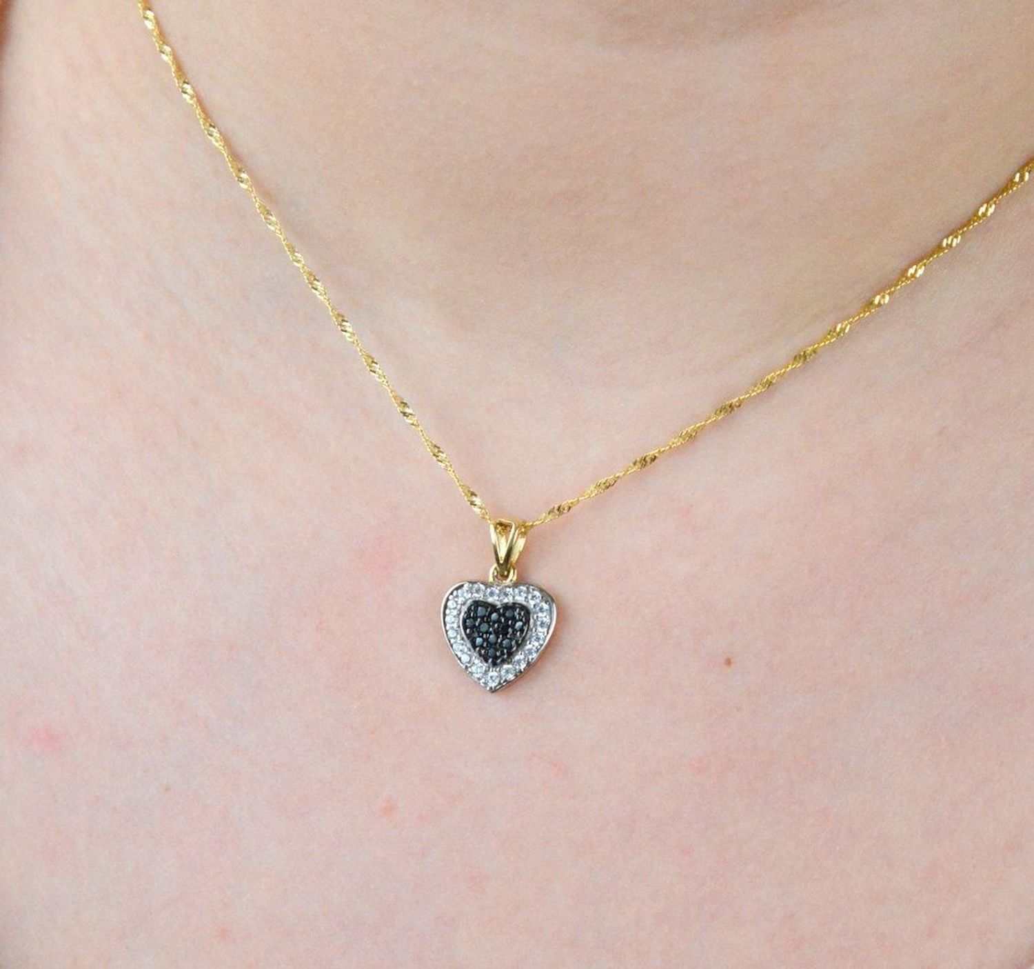 Piękna zawieszka w kształcie serca ozdobiona cyrkonią w kolorze białym i czarnym. Zawieszkę wykonano ze złota próby 585 o wadze 1,87 gram. Do zawieszki można dobrać delikatny złoty łańcuszek.jpg