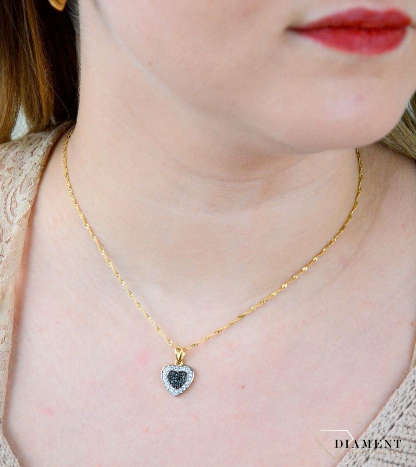 Piękna zawieszka w kształcie serca ozdobiona cyrkonią w kolorze białym i czarnym. Zawieszkę wykonano ze złota próby 585 o wadze 1,87 gram. Do zawieszki można dobrać delikatny złoty łańcuszek.jpg