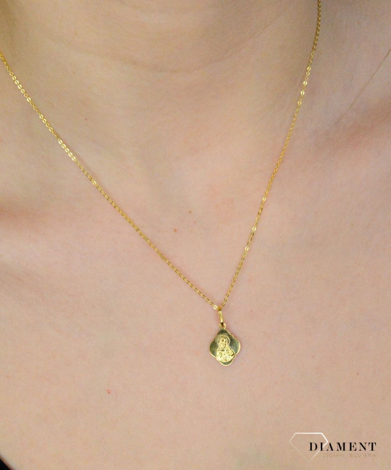 Złota zawieszka 333 medalik Najświętsze serce Jezusa. Złota zawieszka medalik z wizerunkiem Najświętsze serce Jezusa o nieregularnym kształcie. Wielkość medalika to 1,2 cm. Medalik będący wspaniałą pamiątką i prezentem z oka.jpg