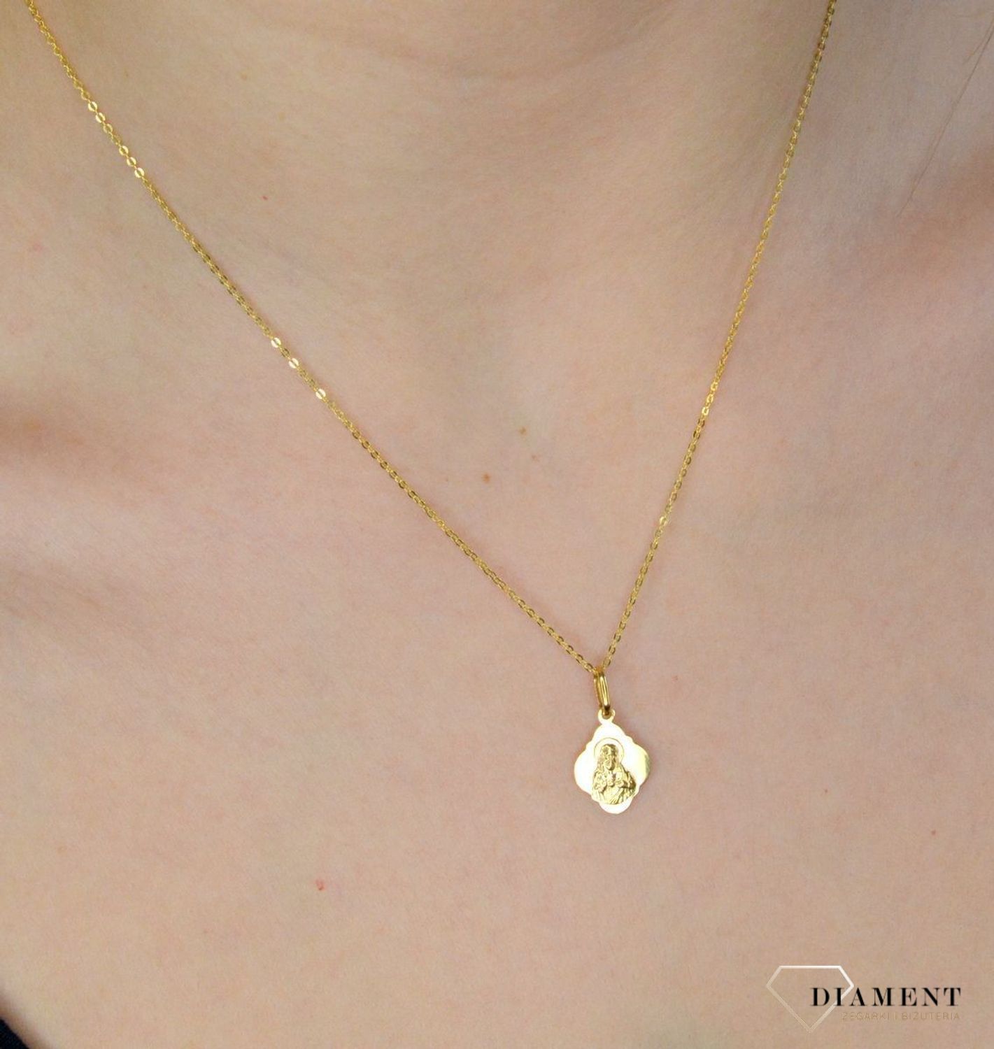 Złota zawieszka 333 medalik Najświętsze serce Jezusa. Złota zawieszka medalik z wizerunkiem Najświętsze serce Jezusa o nieregularnym kształcie. Wielkość medalika to 1,2 cm. Medalik będący wspaniałą pamiątką i prezentem z oka.jpg