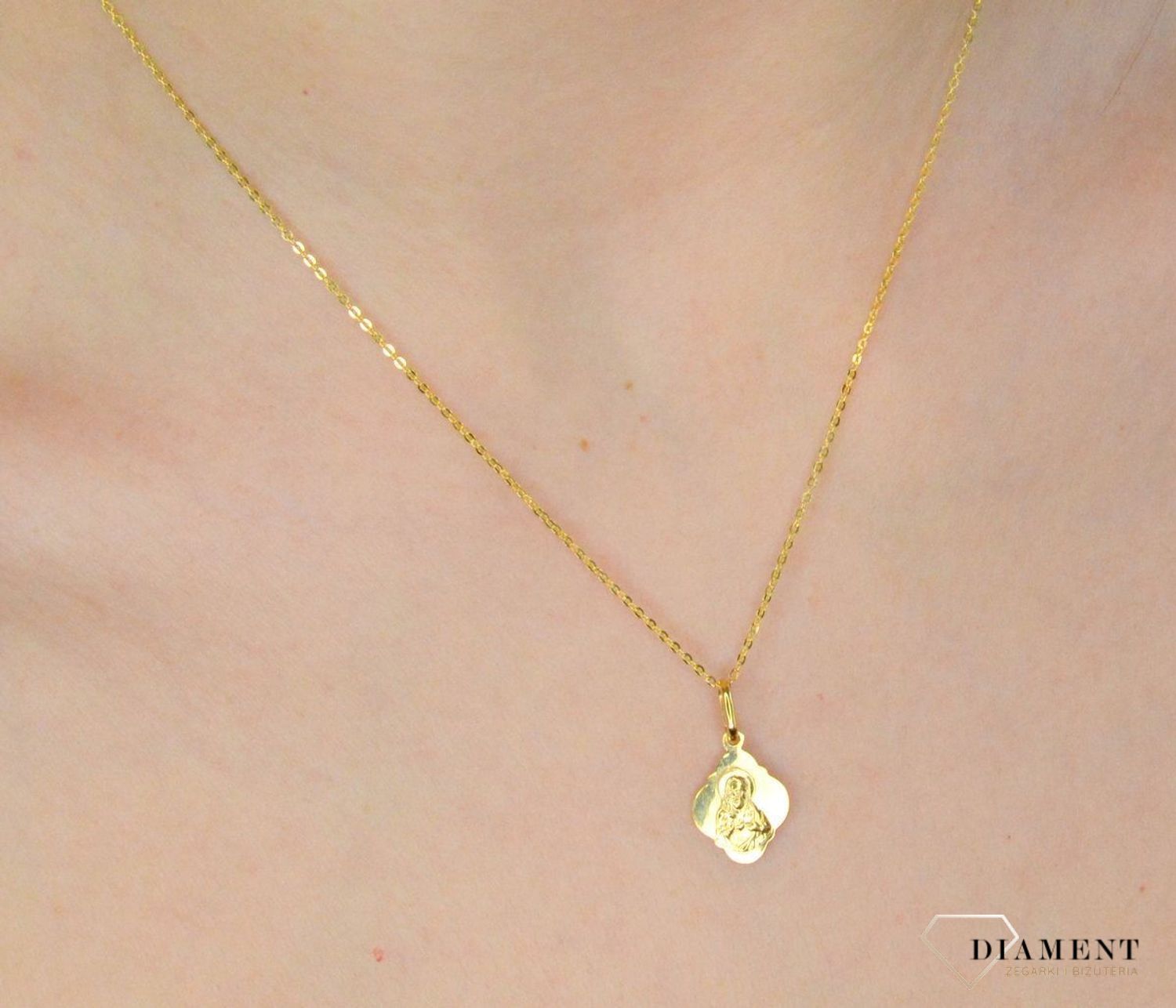 Złota zawieszka 333 medalik Najświętsze serce Jezusa. Złota zawieszka medalik z wizerunkiem Najświętsze serce Jezusa o nieregularnym kształcie. Wielkość medalika to 1,2 cm. Medalik będący wspaniałą pamiątką i prezentem z oka.jpg