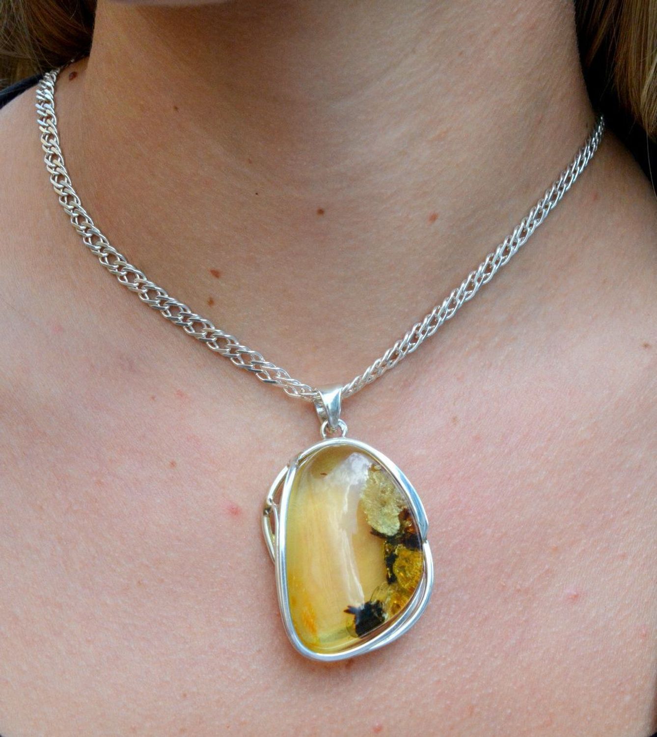 Zawieszka srebrna z bursztynem DIA-ZAW-7045-925. Bursztyn wprawiono w najwyższej jakości srebro o próbie 925, kruszec od wielu setek lat symbolizujący głębię emocjonalną, duchowość i żeńską energię.jpg