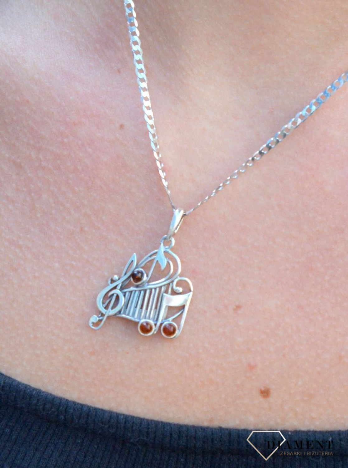 Zawieszka srebrna w kształcie nutek z bursztynem  DIA-ZAW-7130-925. Bursztyn wprawiono w najwyższej jakości srebro o próbie 925, kruszec od wielu setek lat symbolizujący głębię emocjonalną, duchowość i żeńską energię.jpg